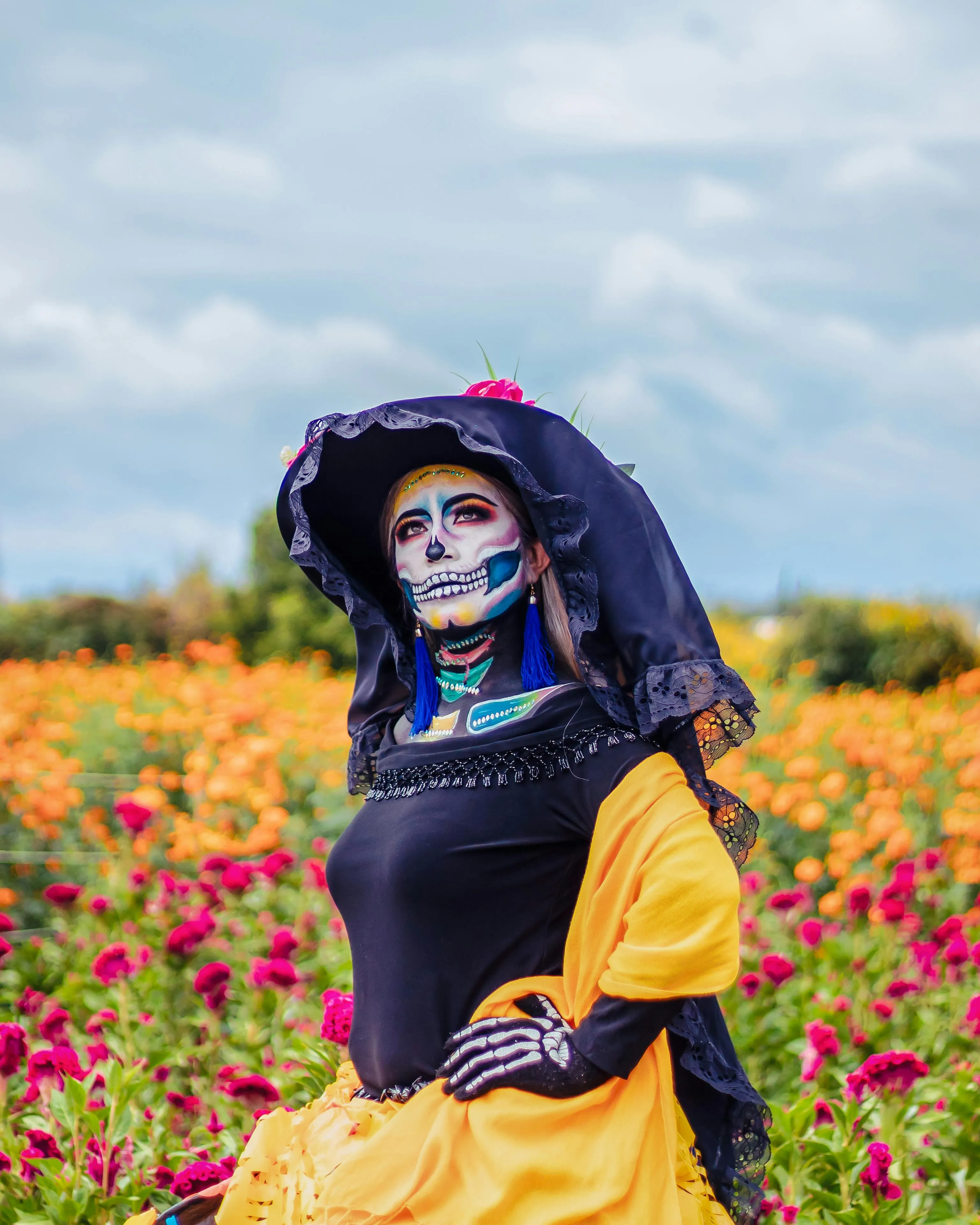 Woman Wearing Colorful Dress and Skull Makeup in Field