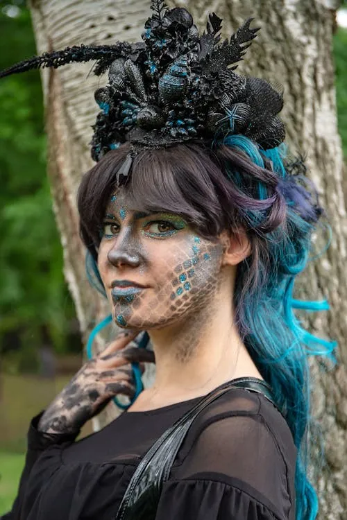 Woman with blue hair and dark crown in Halloween costume