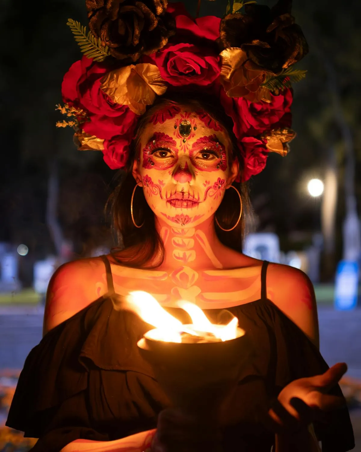 Woman with Floral Headpiece and Face Paint Holding Flame