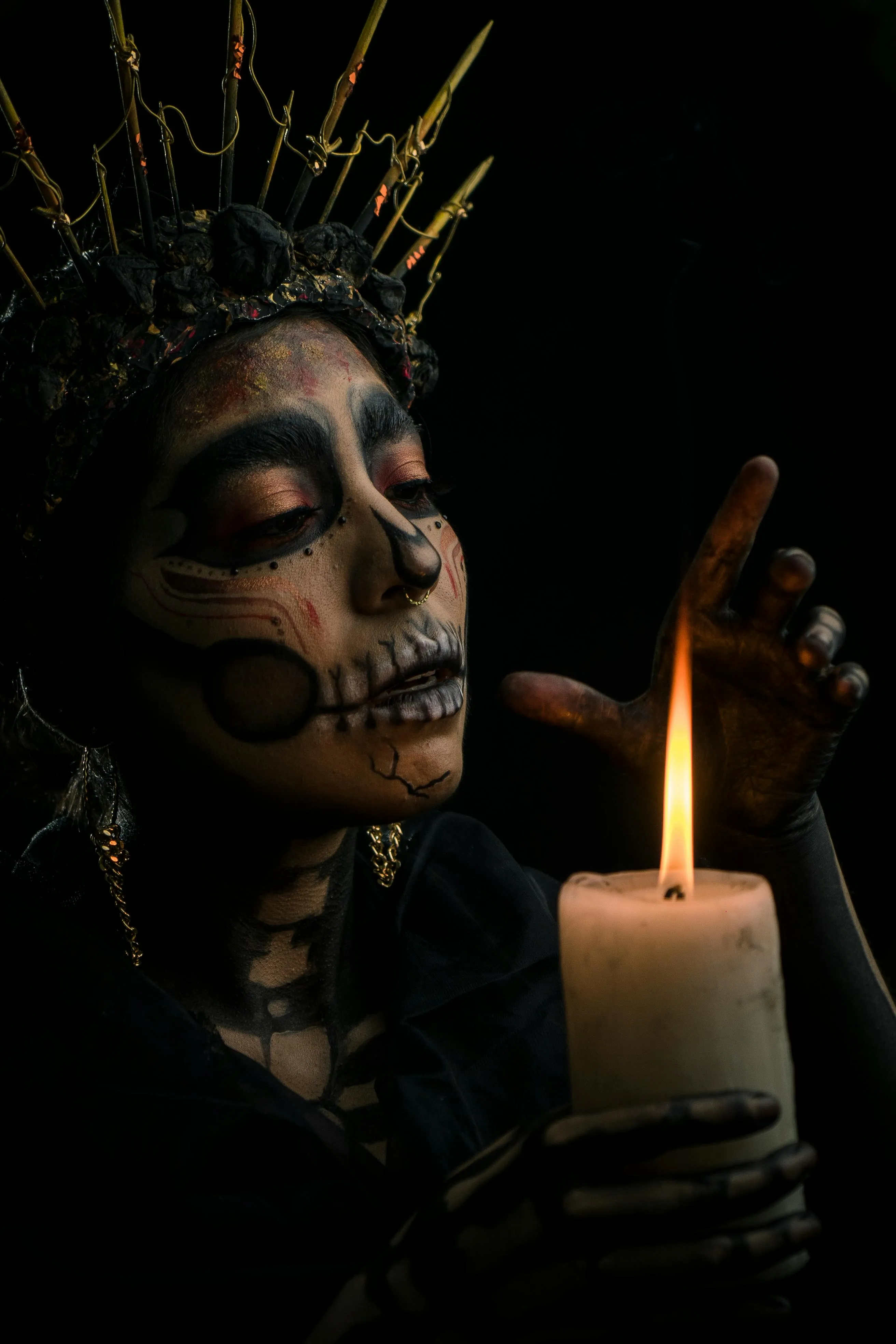 Woman with Skeleton Makeup Holding Candle in Darkness