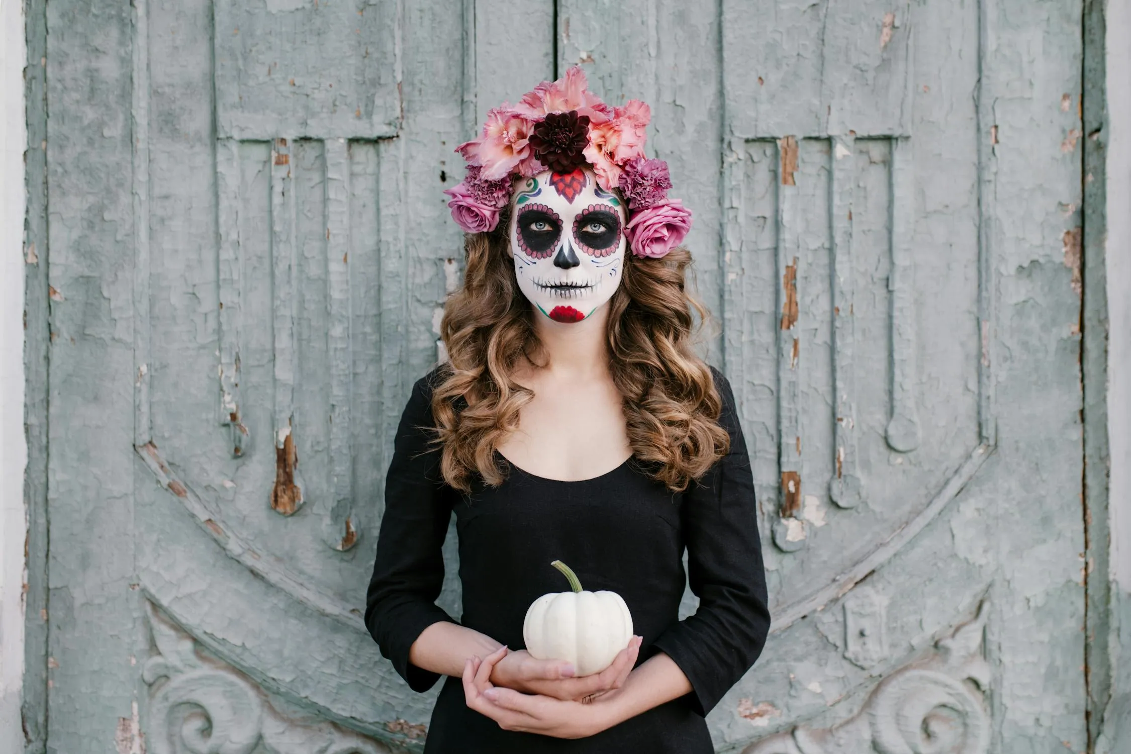 Woman with Sugar Skull Makeup Holding a Pumpkin Wallpaper
