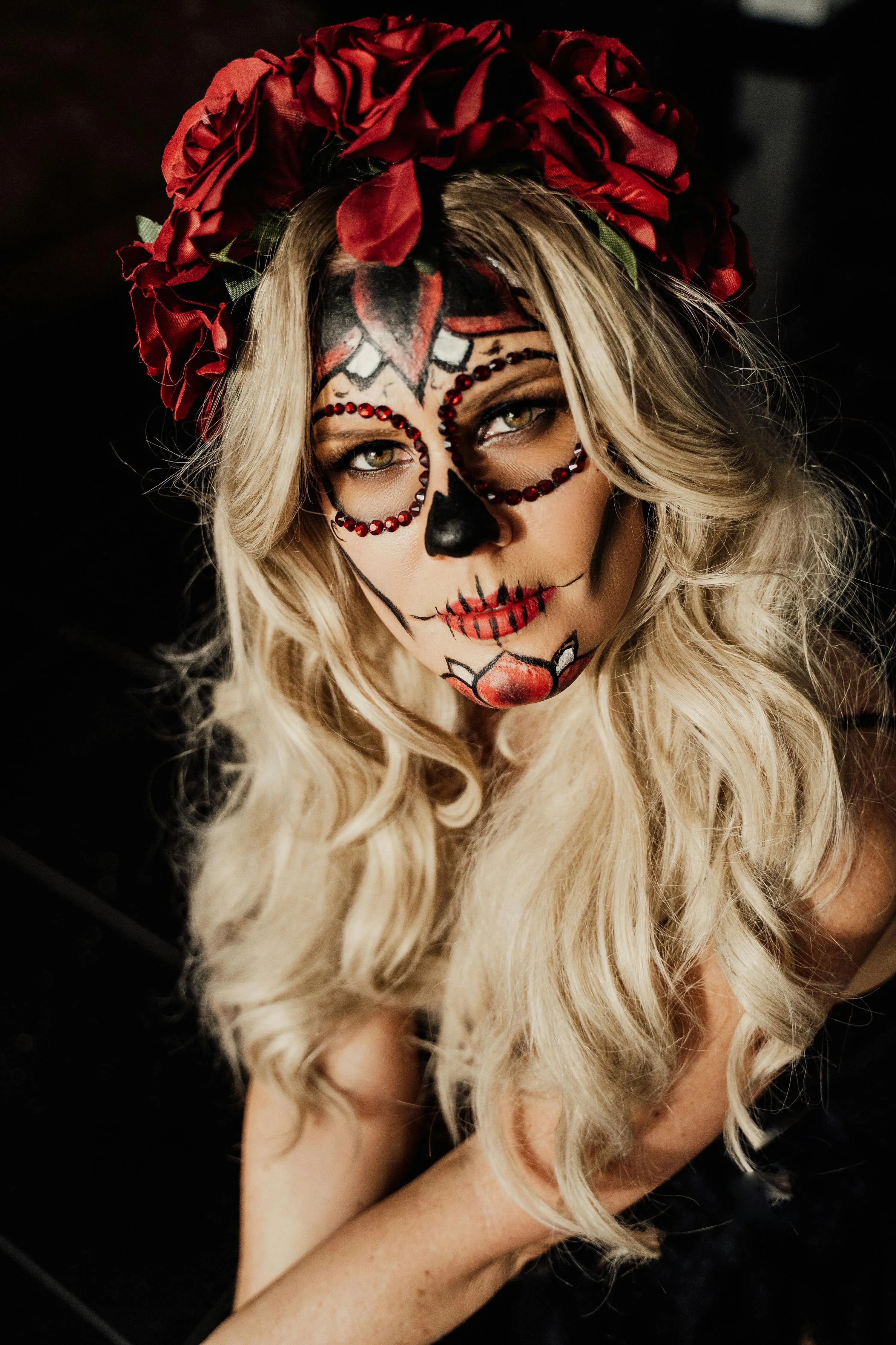Women in Stunning Halloween Festival Makeup with Red Flowers