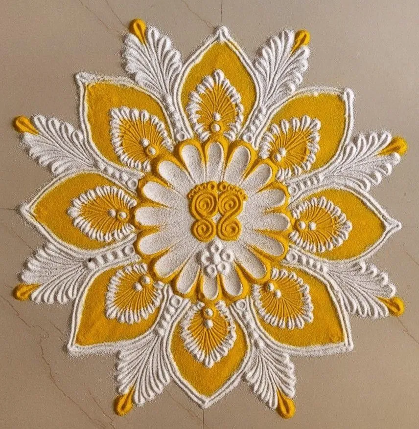 Yellow and white rangoli design for Onam celebration image