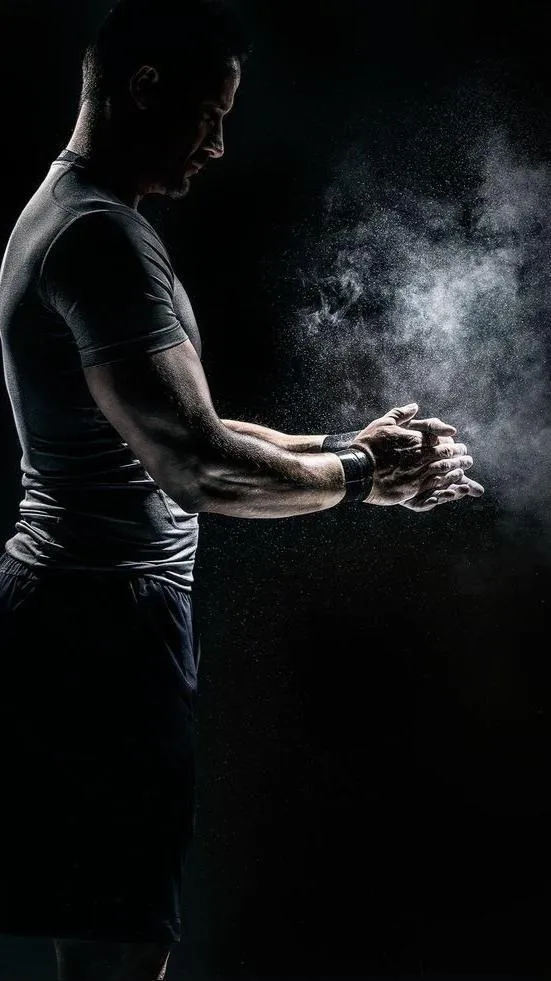Athlete Chalking Hands Preparing For an Intense Workout