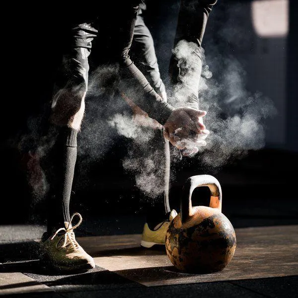 Athlete Preparing For Kettlebell Workout With Chalked Hands