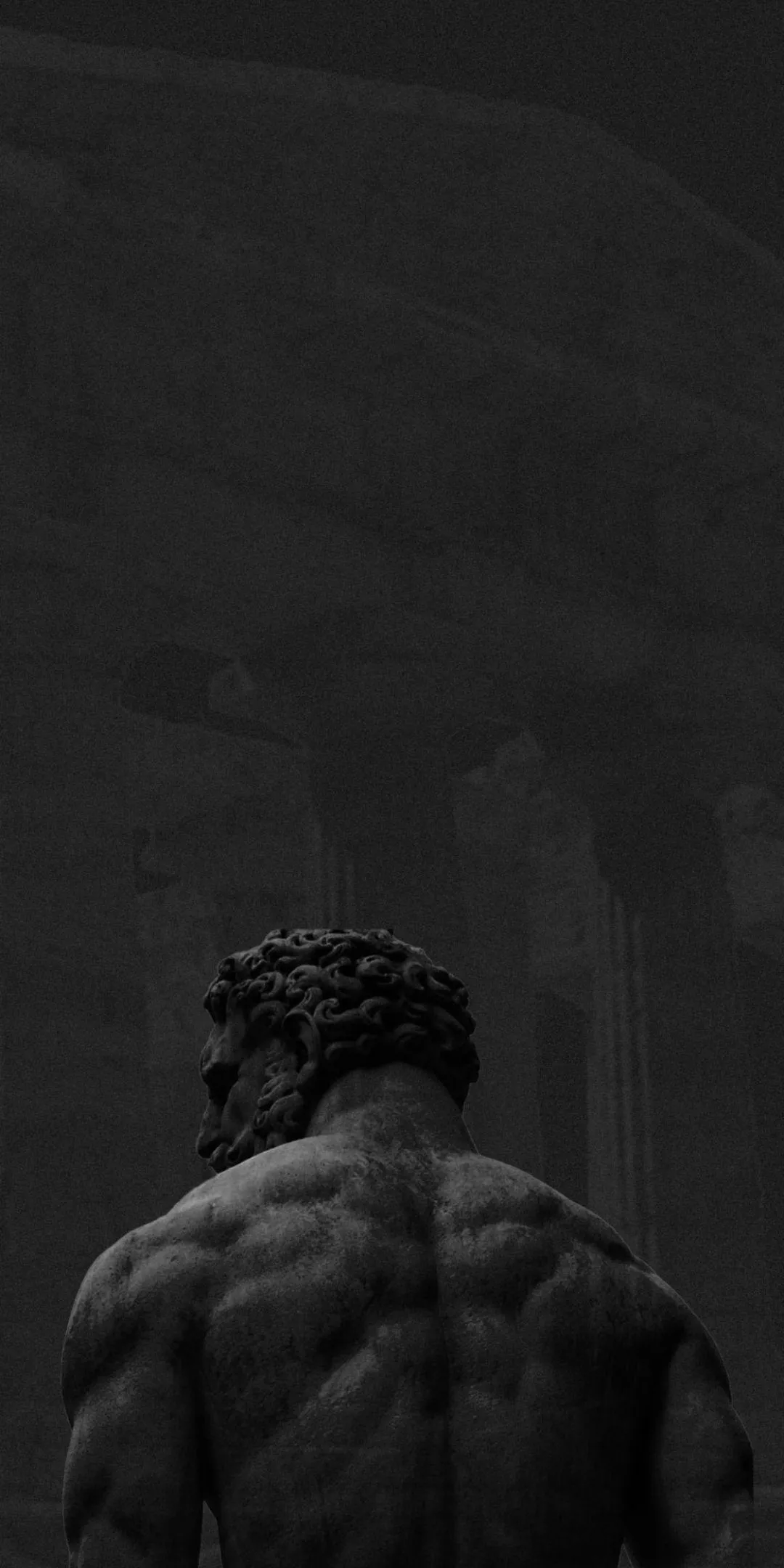 Back View of a Muscular Man Standing Alone in the Shadows