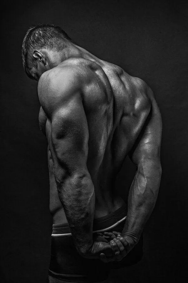 Black and White Photo of a Man Showing Defined Back Muscles