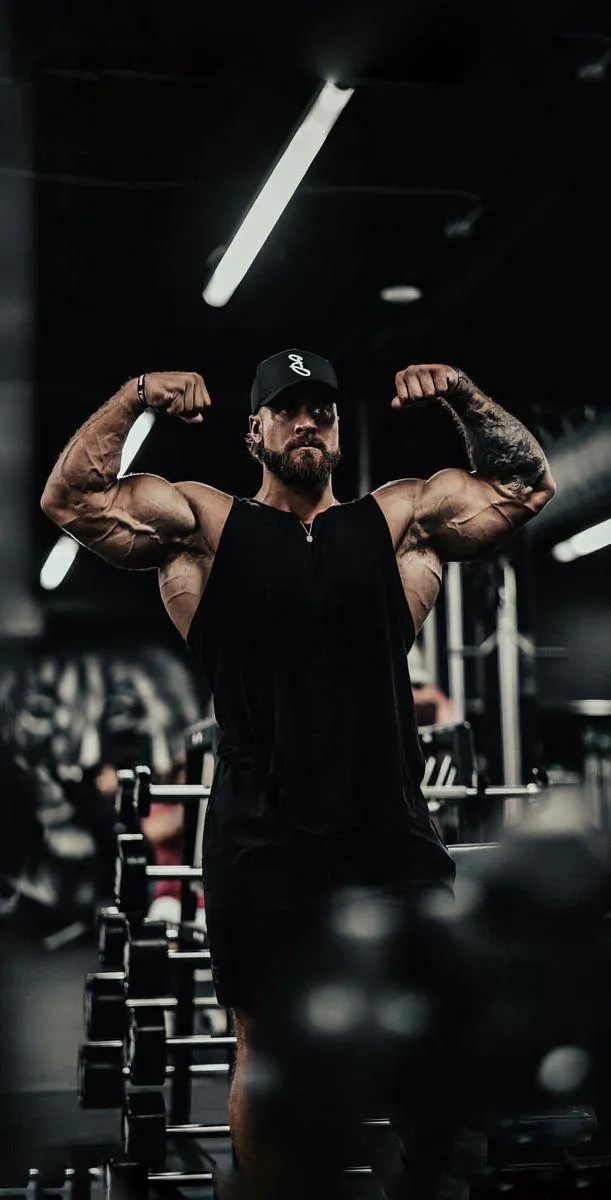 Bodybuilder Flexing Muscles in the Gym Portrait Wallpaper