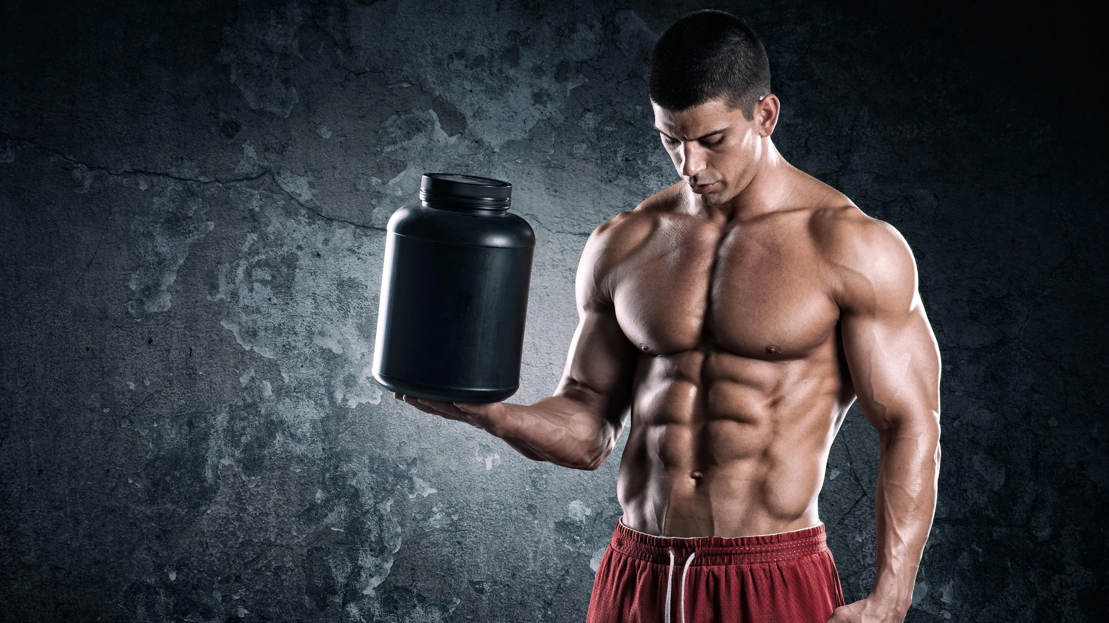 Bodybuilder Holding a Supplement Container Hd Free Wallpaper