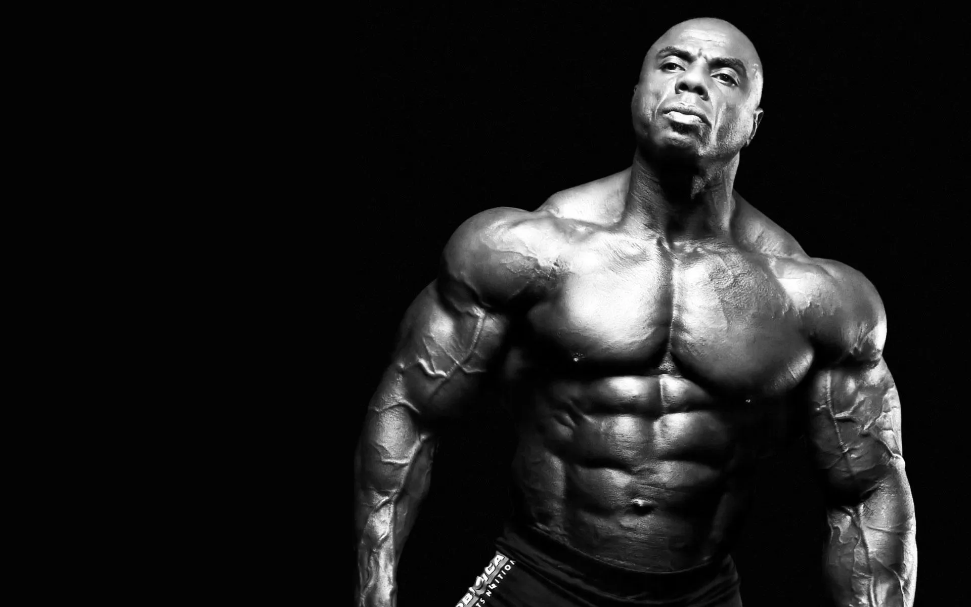Bodybuilder With a Serious Face Posing Shirtless Wallpaper
