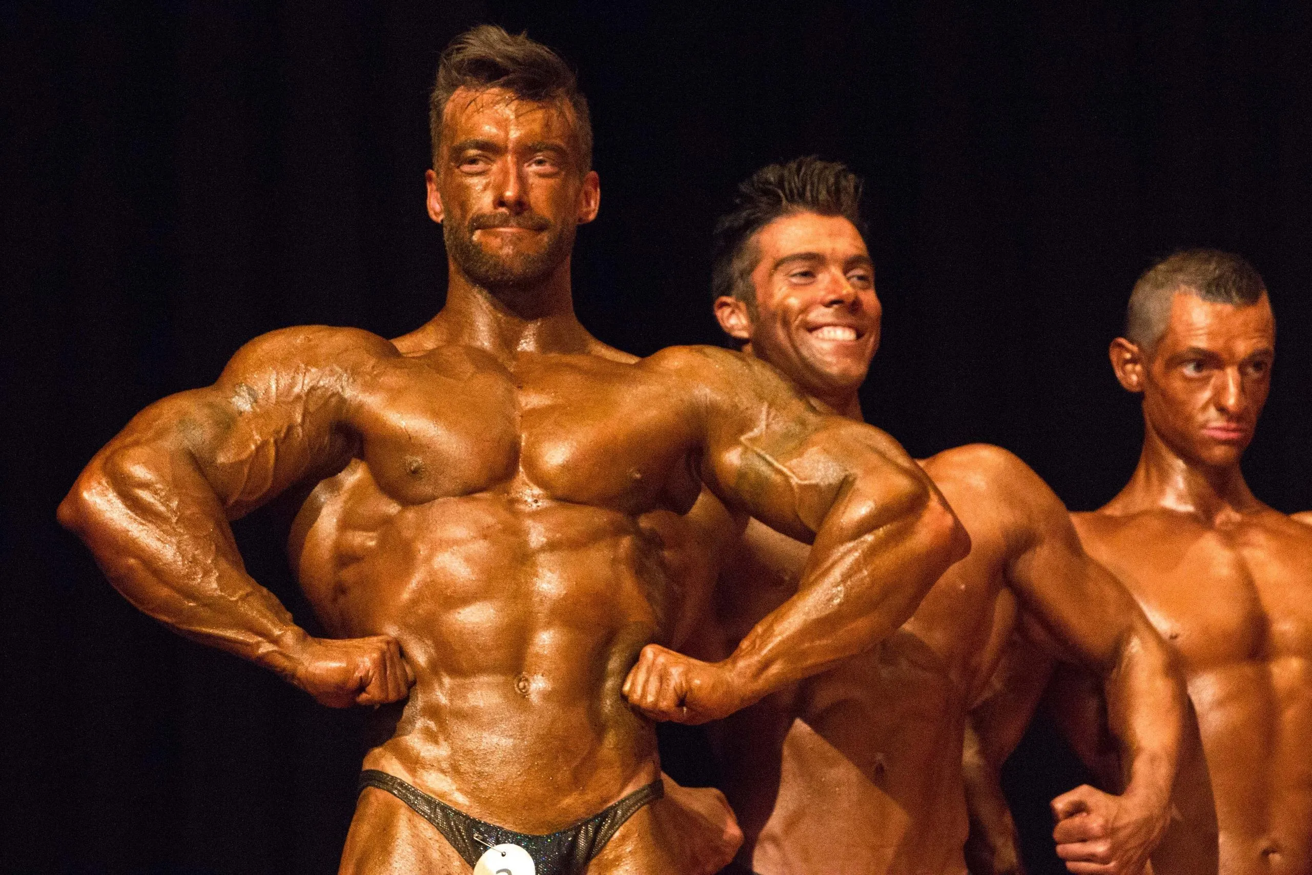 Bodybuilders Flexing Chest Muscles in a Stage Competition