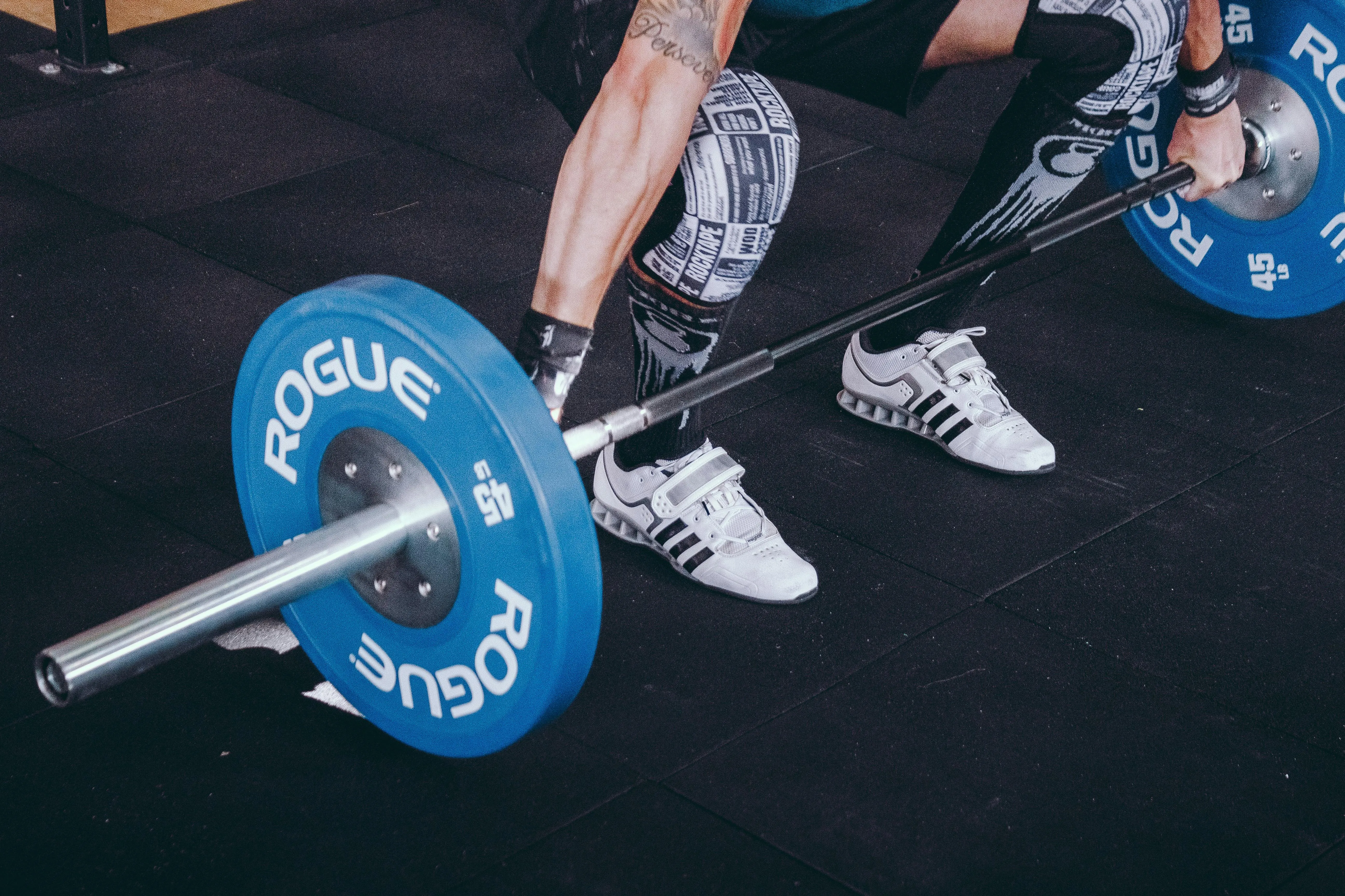Close Up of Feet Lifting Barbell Plates in Gym Workout