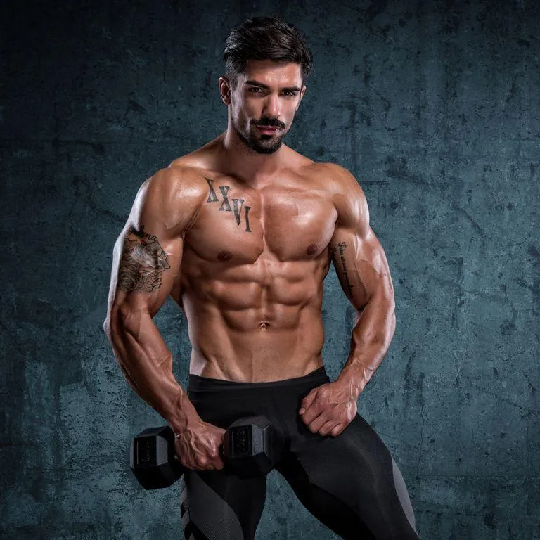 Confident Man Holding Dumbbells Showing Muscles Wallpaper