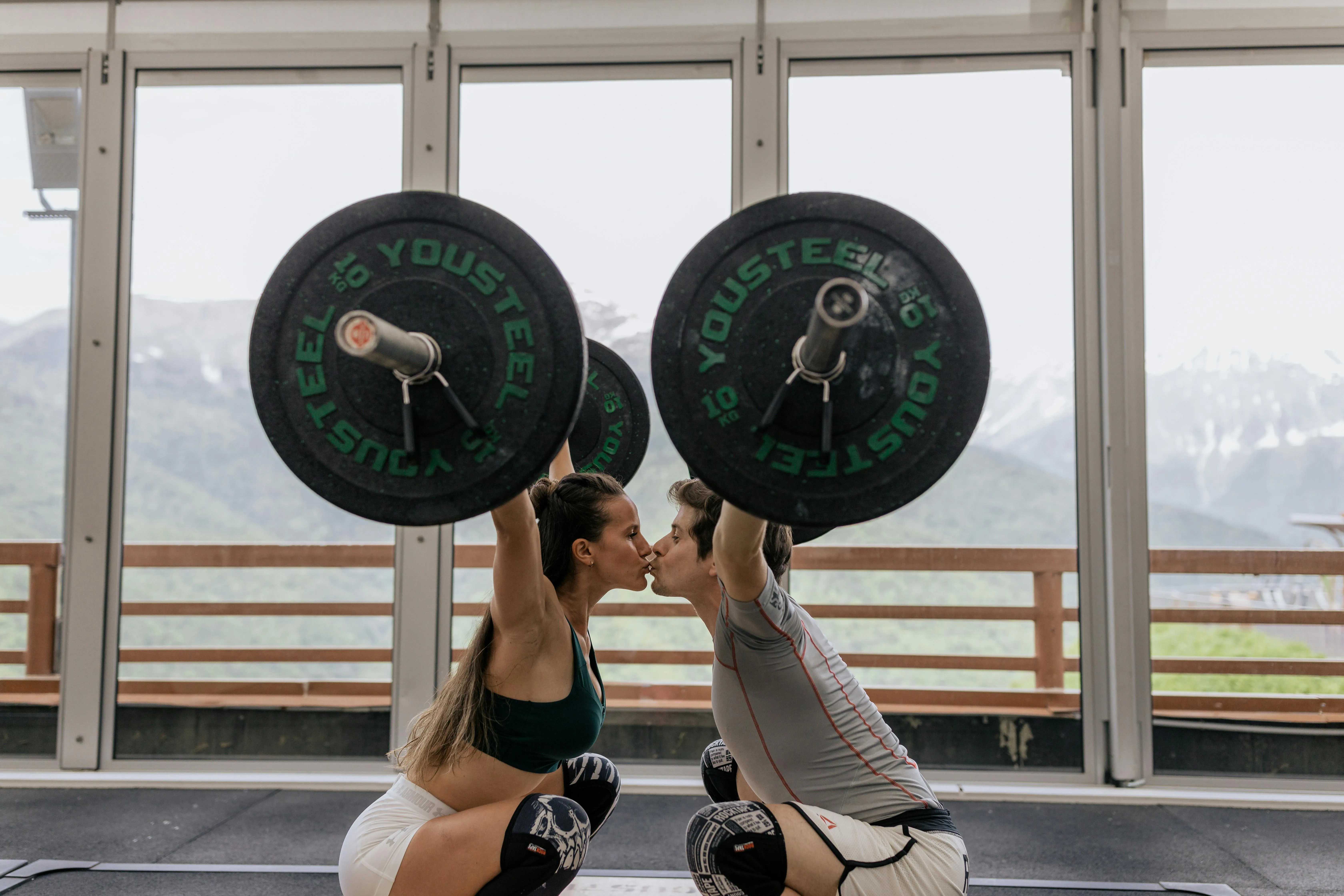 Couple Doing Partner Leg Press Exercise in a Bright Gym