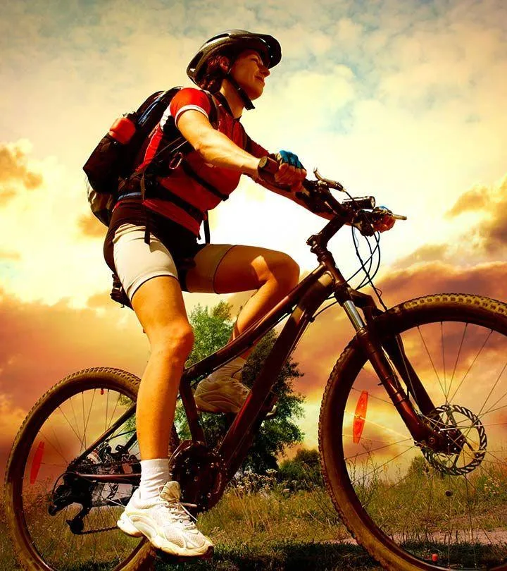 Cyclist Riding a Mountain Bike Uphill At Sunrise Wallpaper