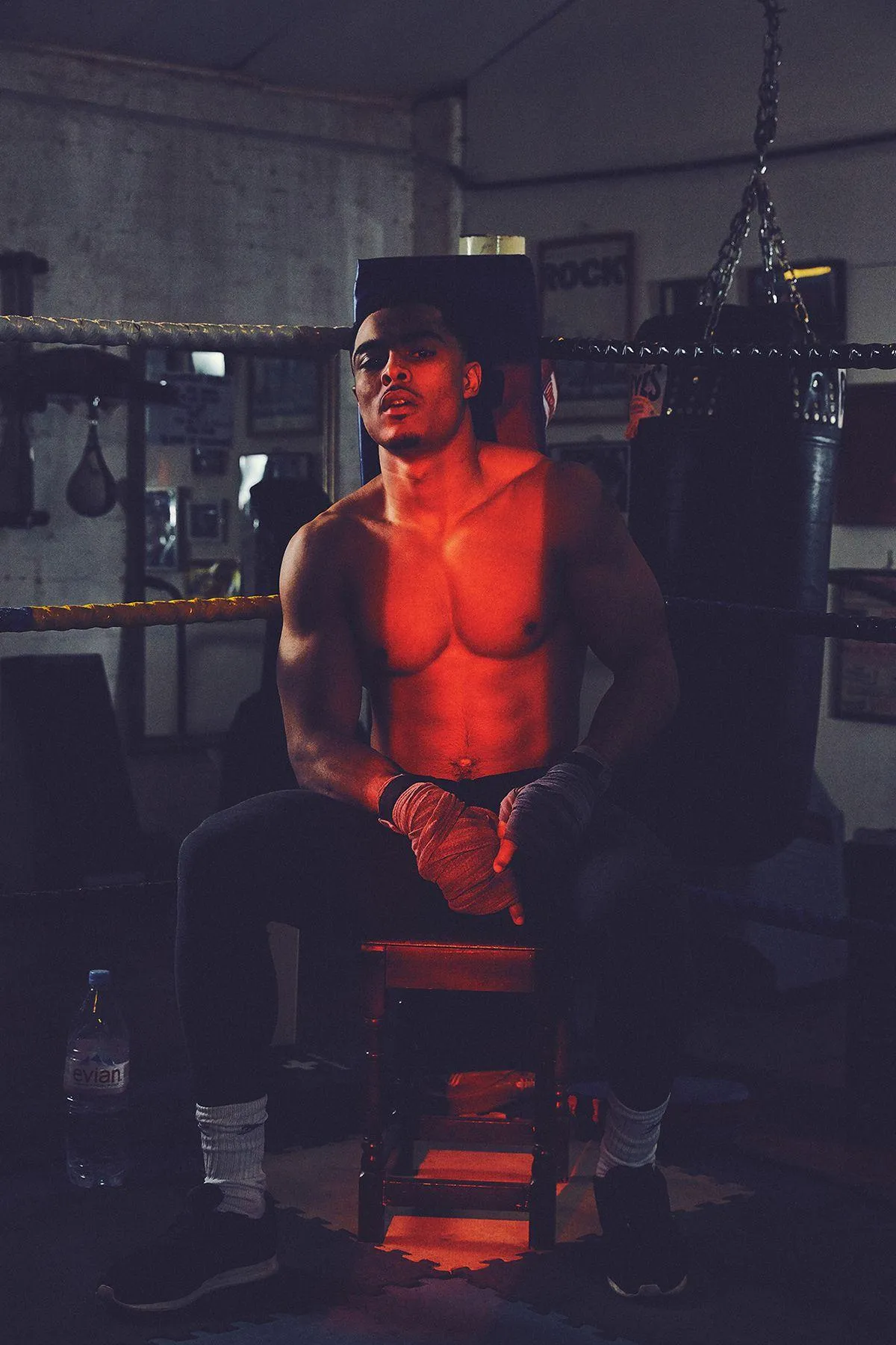 Dimly Lit Gym Photo of Man Resting on a Bench After Workout