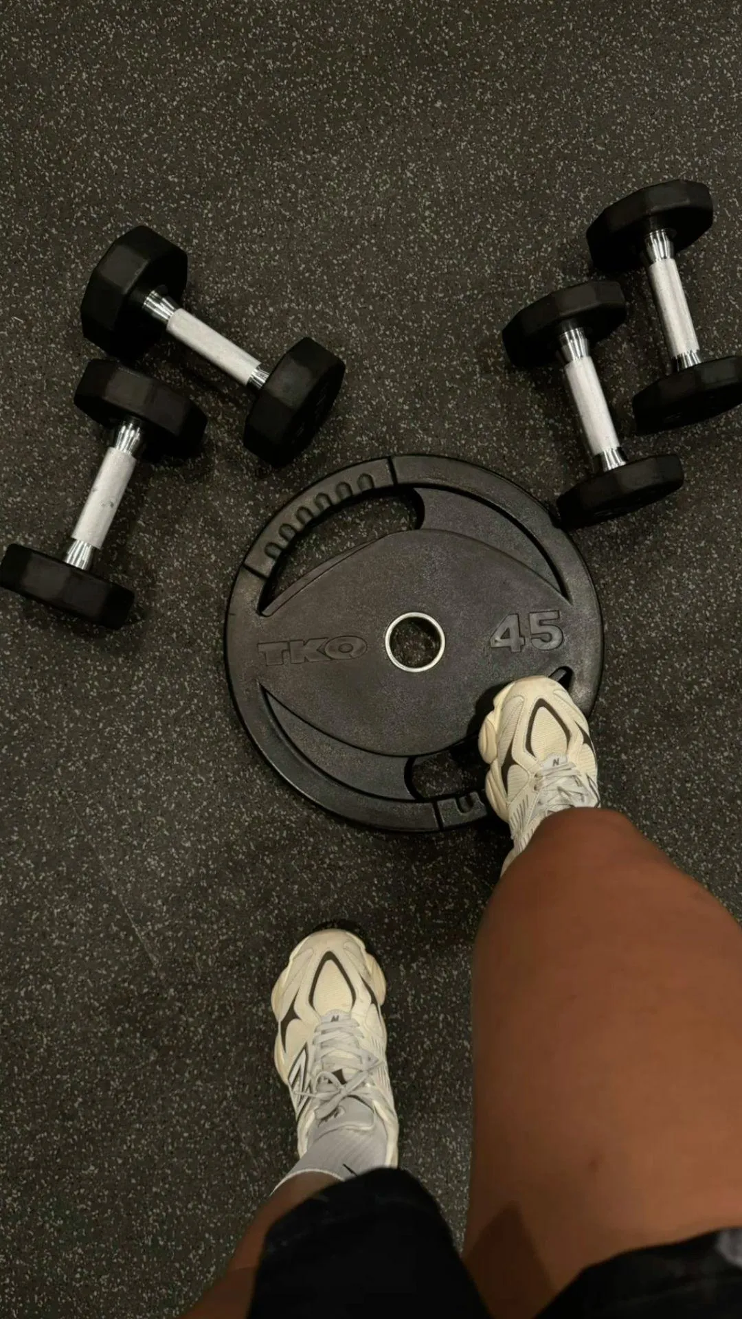 Feet Near Dumbbells and a Weight Plate on the Gym Floor