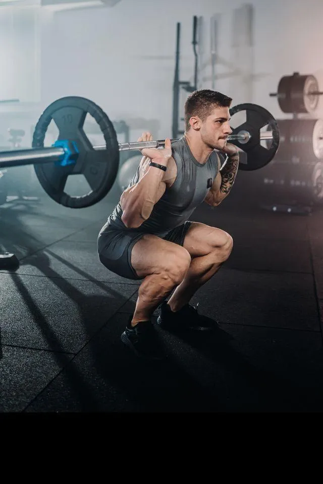 Focused Man Doing Barbell Squats During a Gym Leg Workout