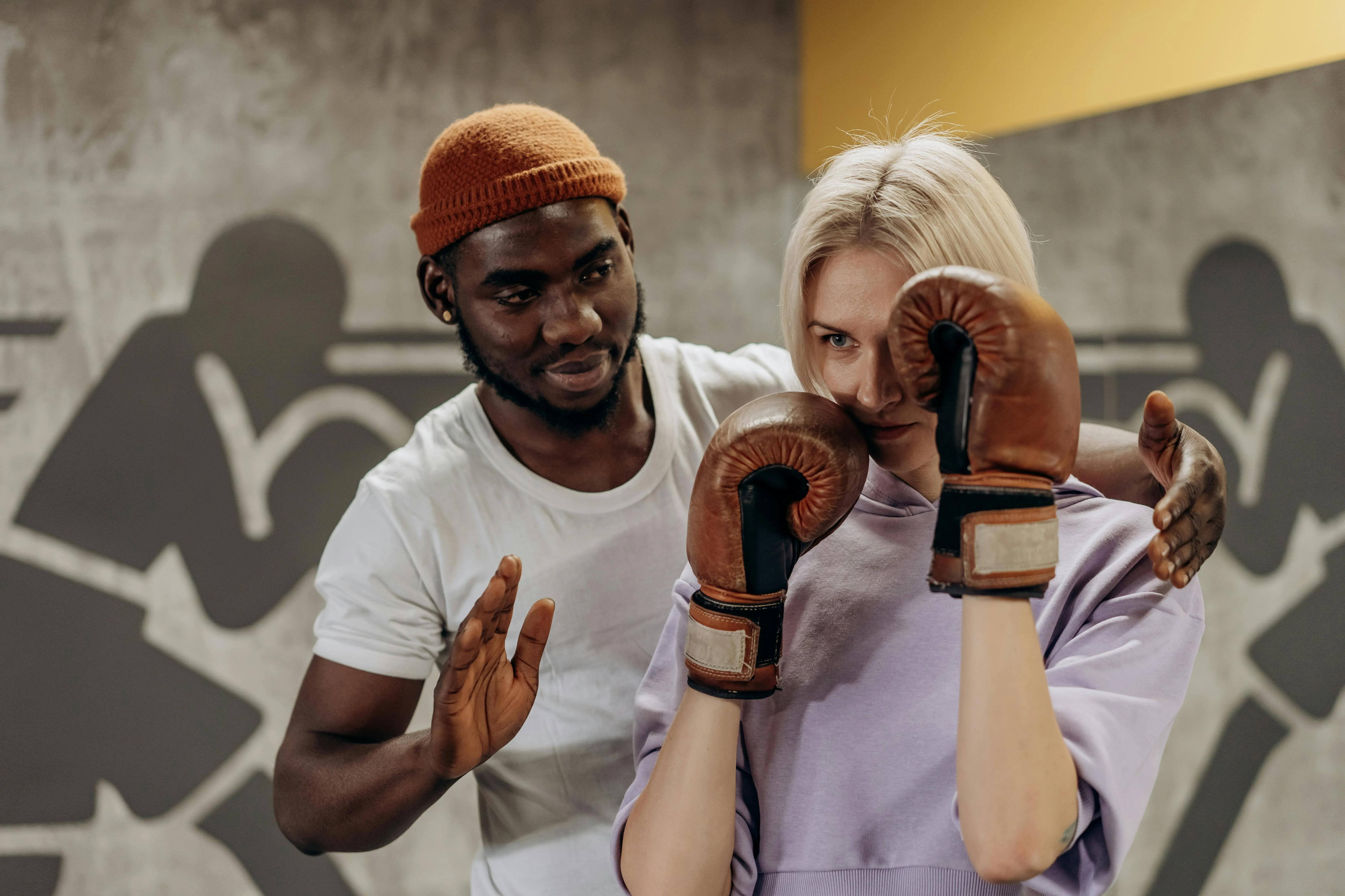 Friendly Boxing Coach Guiding a Woman in Gym Training