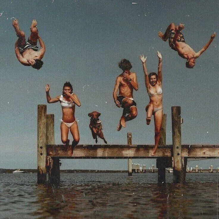 Group of Friends Jumping Off Dock Into the Water Wallpaper