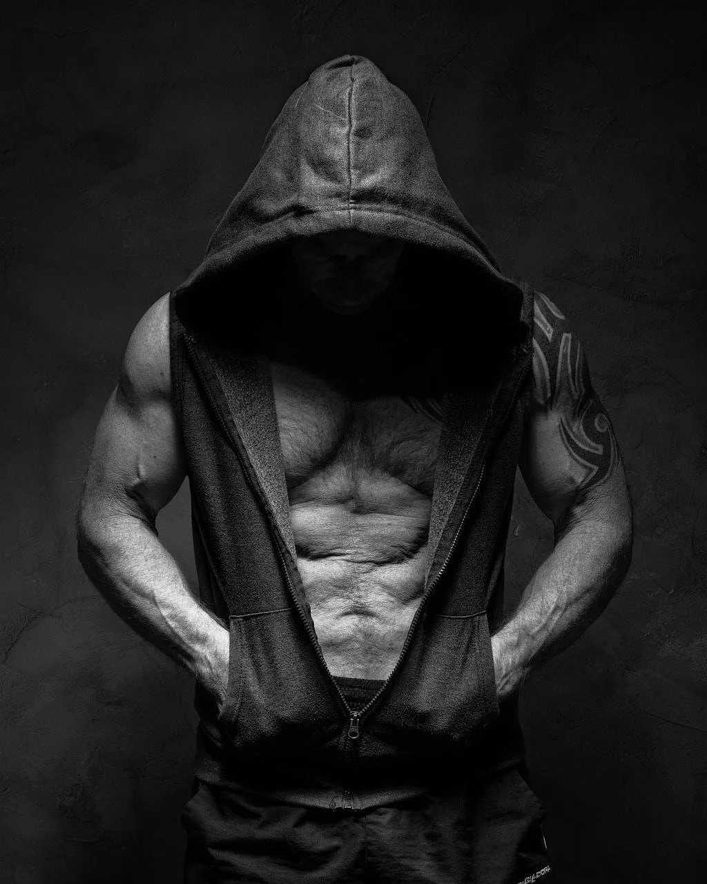 Hooded Man Showing Shredded Abs in Dark Dramatic Lighting