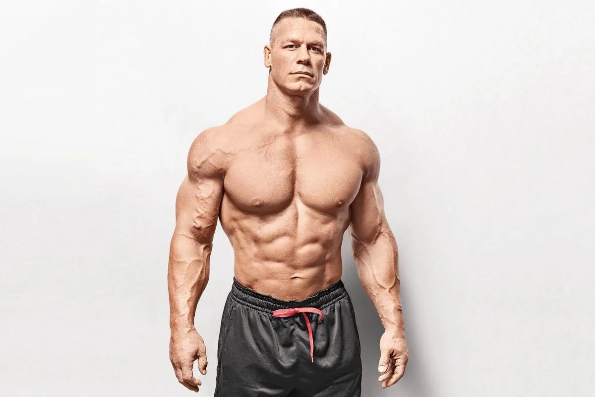 John Cena Flexing Shirtless in Front of a White Wall