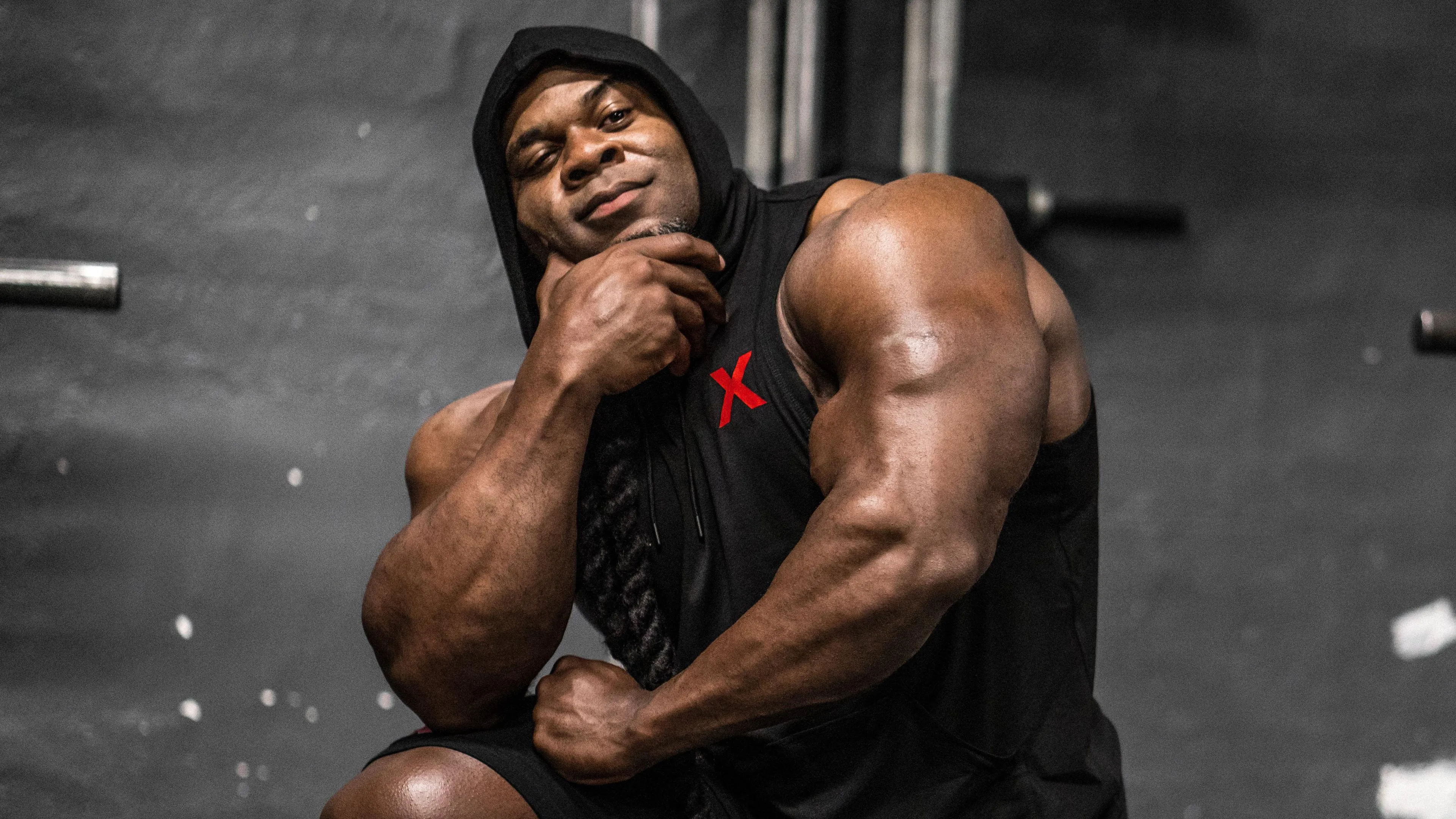 Kai Greene on Gym Bench With Flexed Arm and Focus Wallpaper