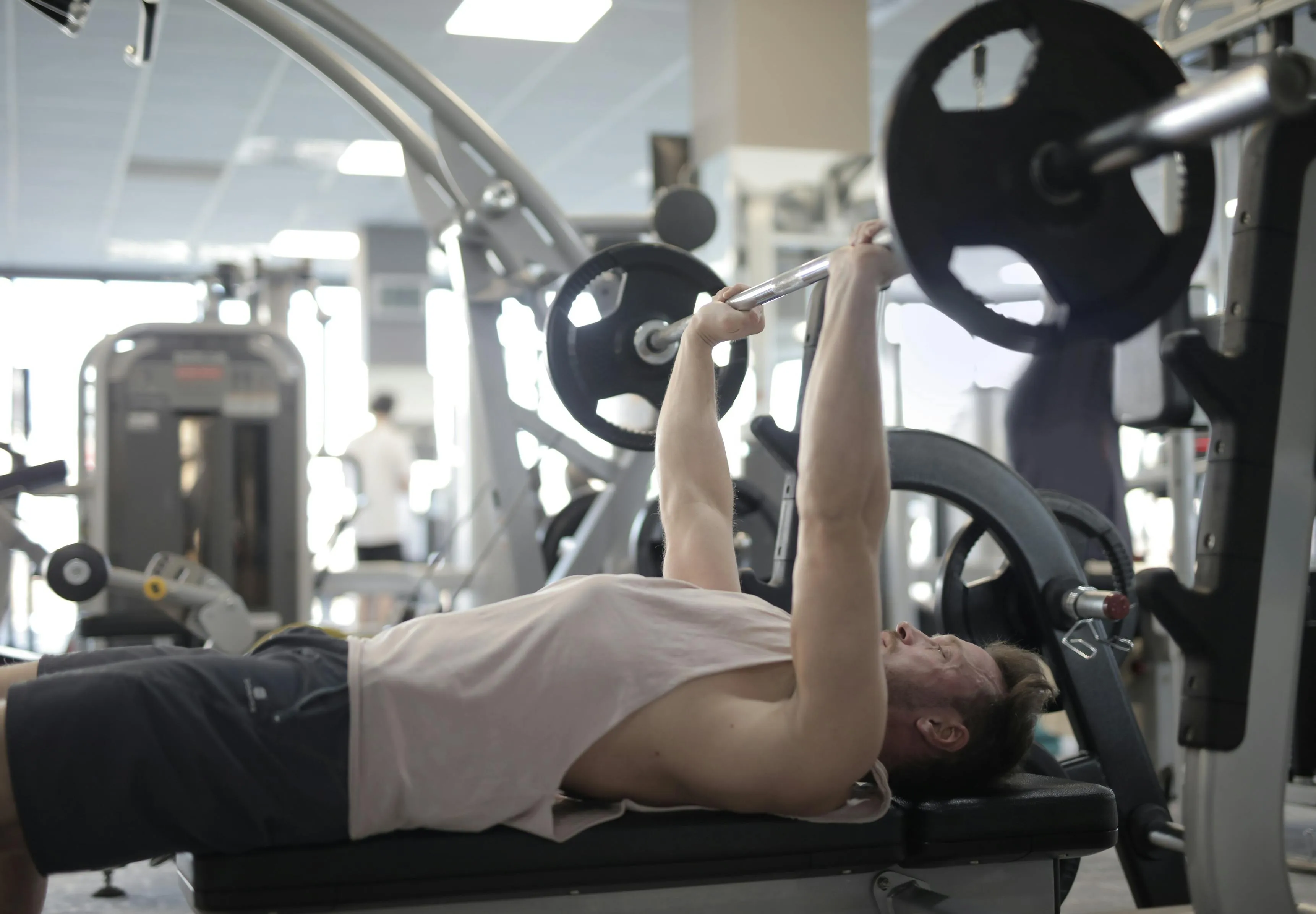 Man Doing Chest Workout on a Seated Machine At Gym Wallpaper