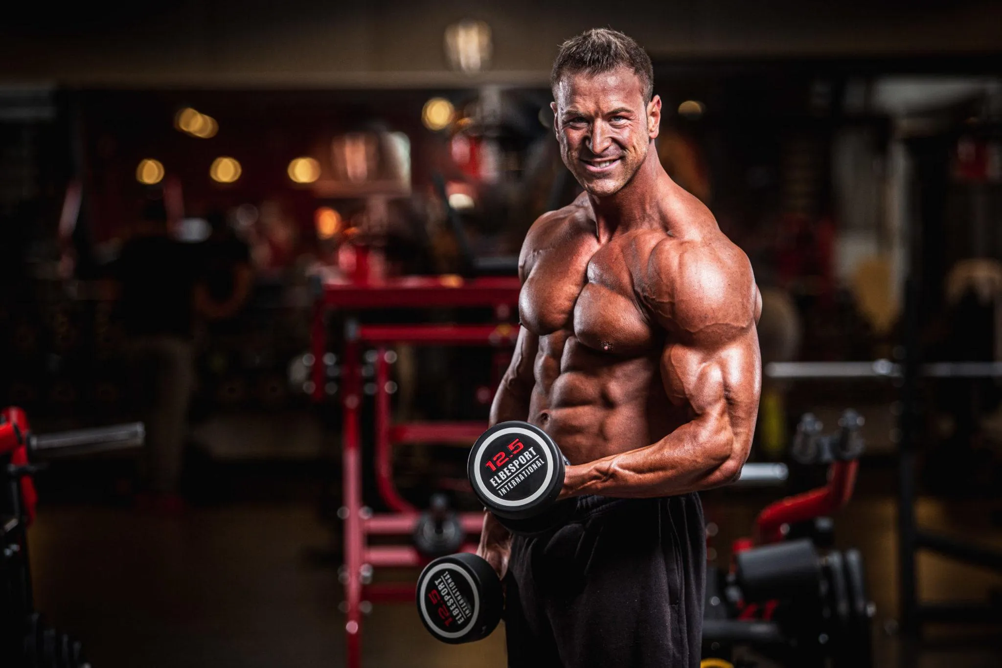 Man Doing Dumbbell Curls in a Brightly Lit Fitness Gym