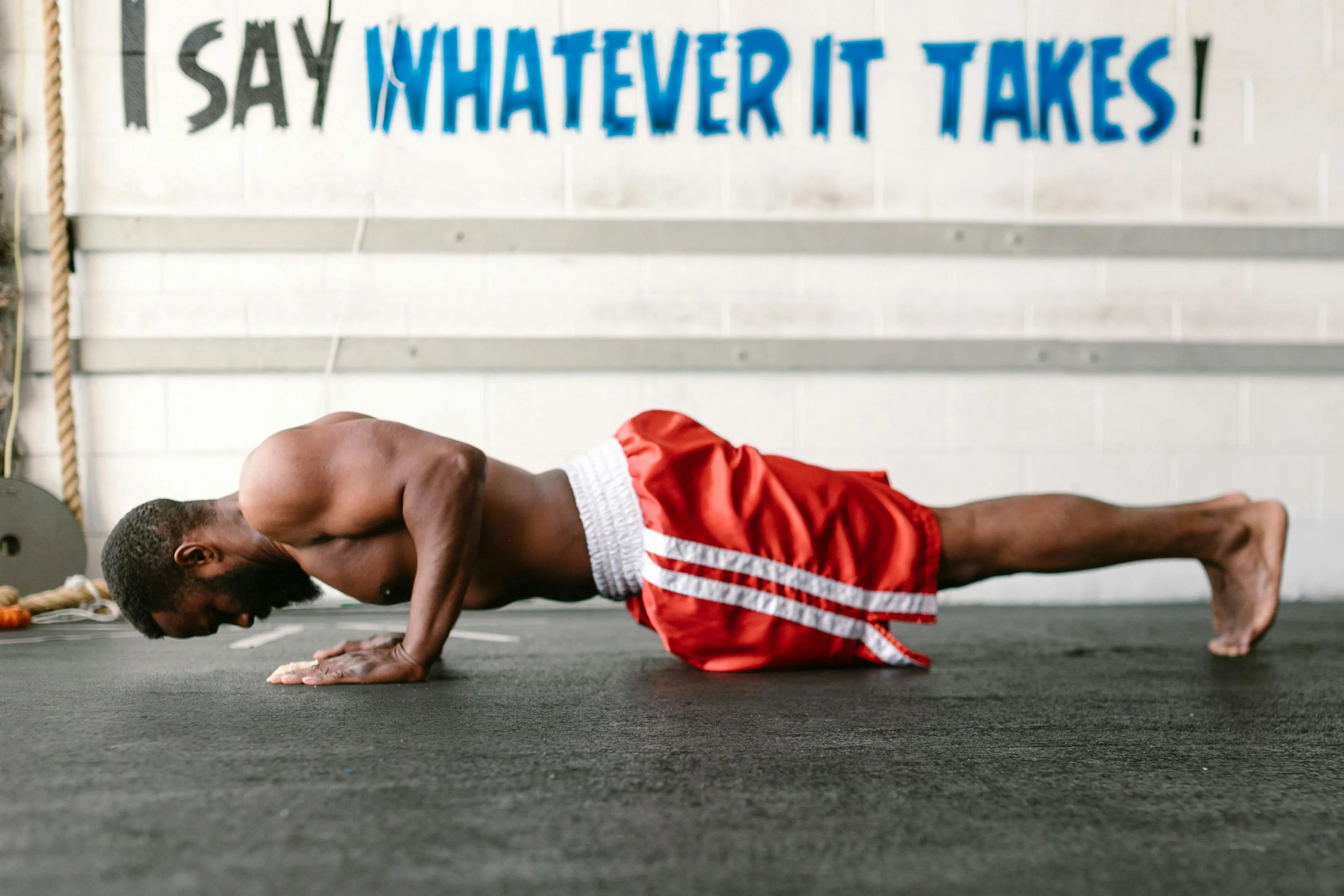 Man Doing a Floor Plank Beside a Motivational Wall Message