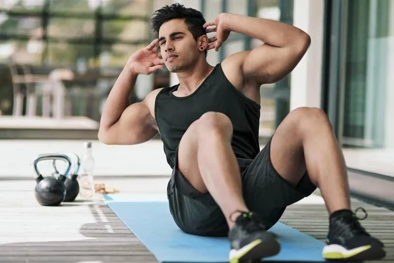 Man Doing Sit Ups on a Yoga Mat During a Morning Workout
