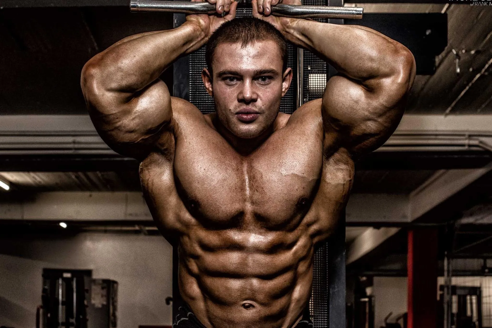 Man Flexing Chest With Hands on Head and Strong Gaze