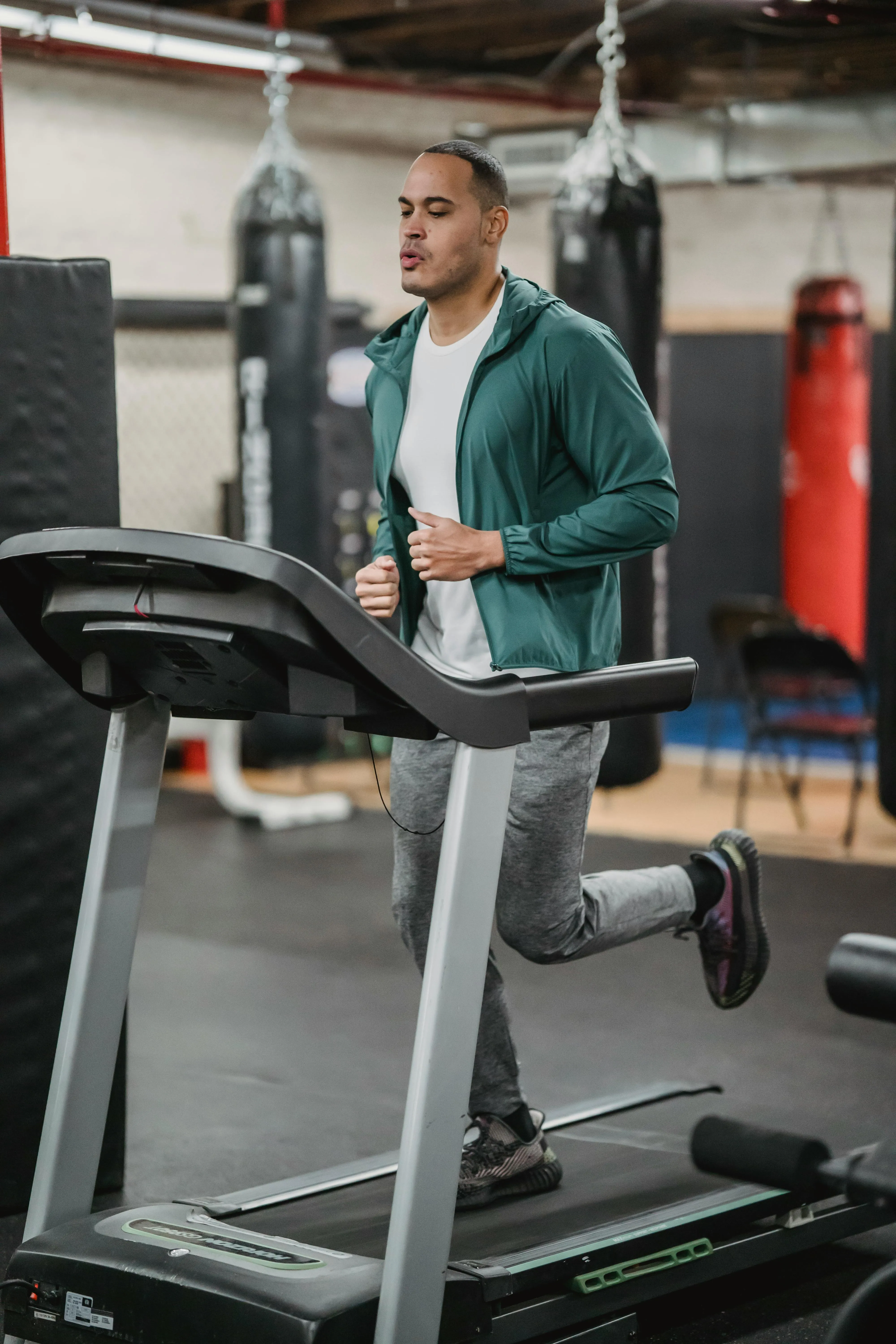 Man With Green Jacket Jogging on Treadmill Hd Free Wallpaper