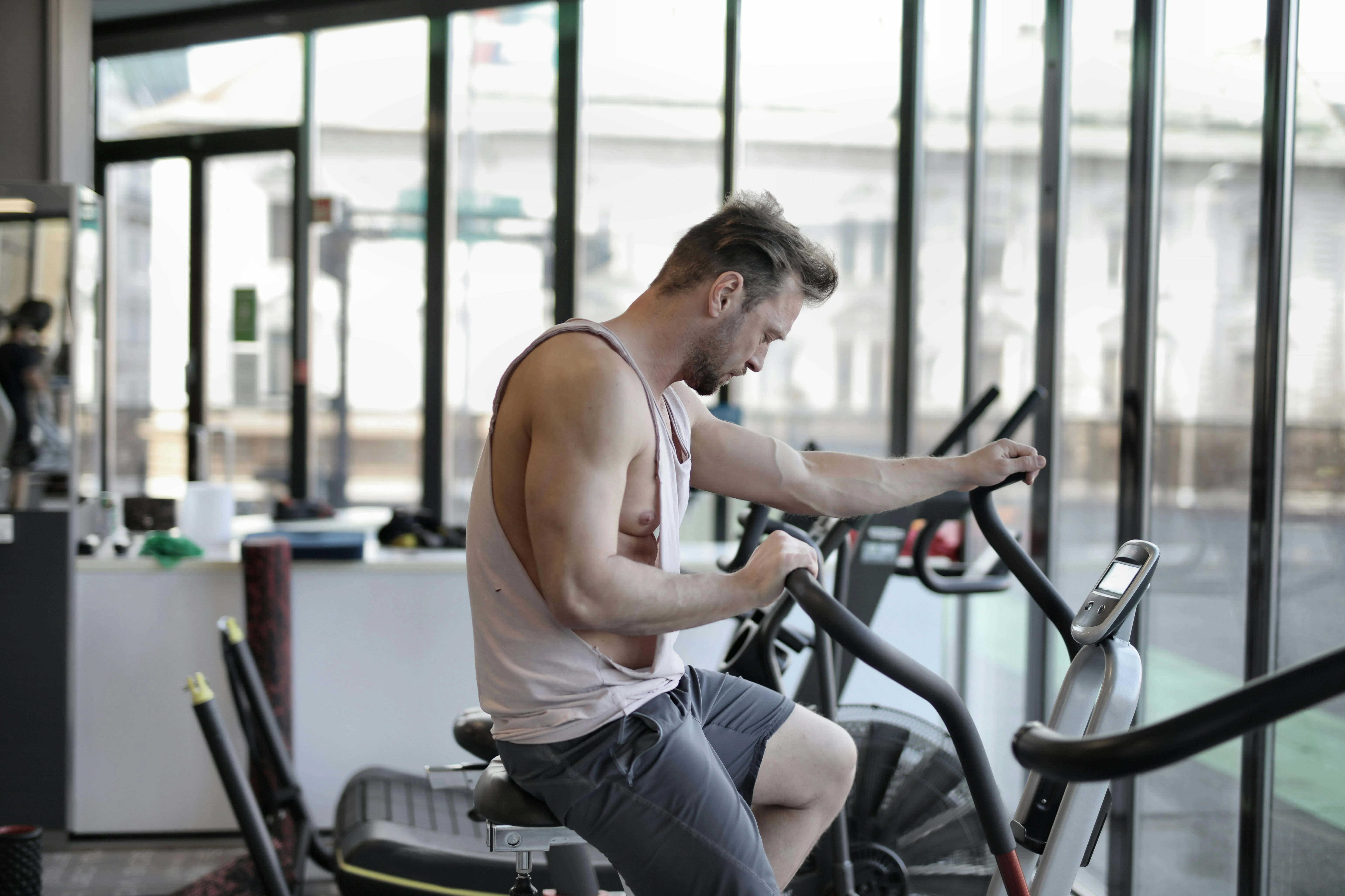Man Pedaling on a Stationary Exercise Bike Free Wallpaper