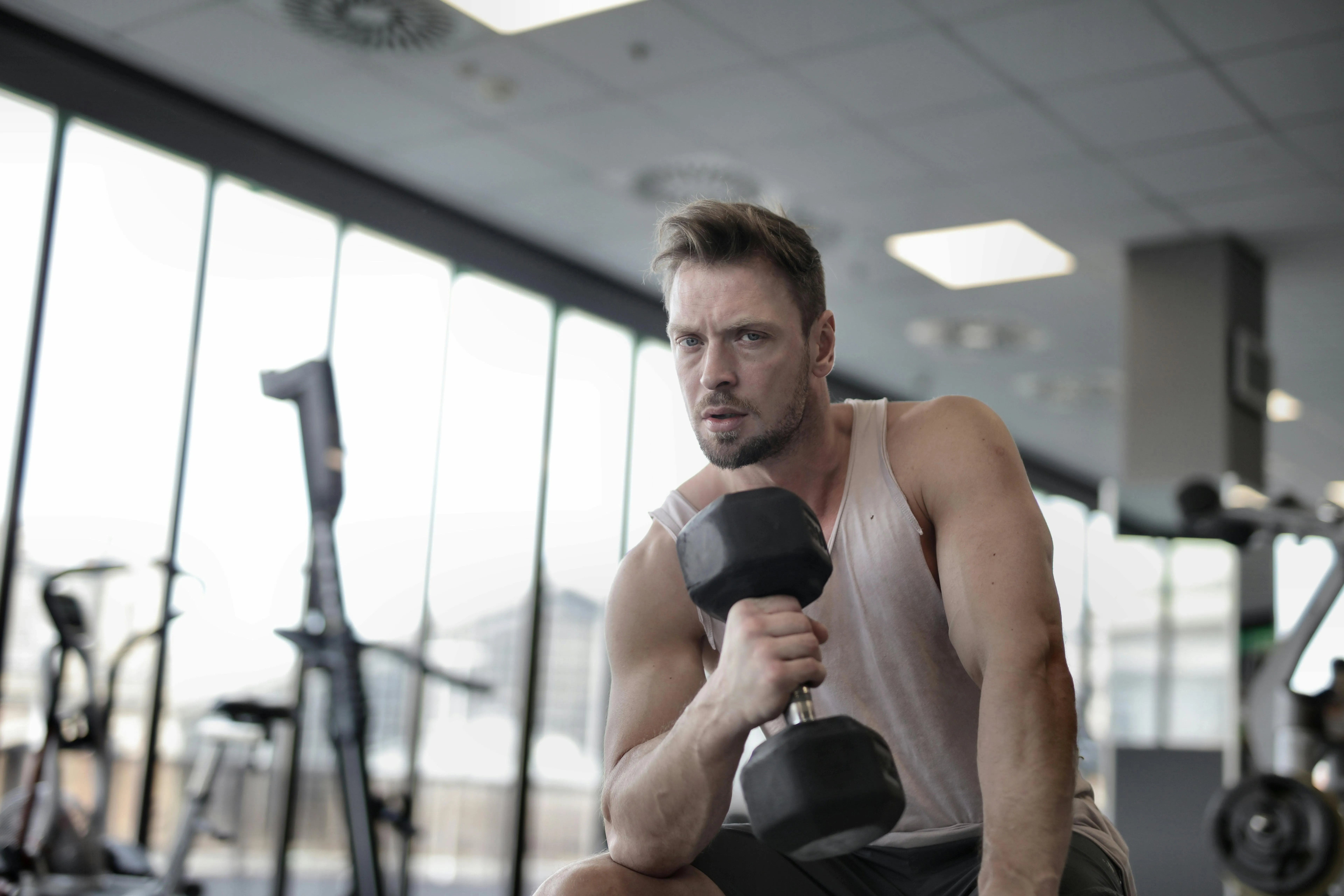 Man Performing Dumbbell Curls To Strengthen Free Wallpaper