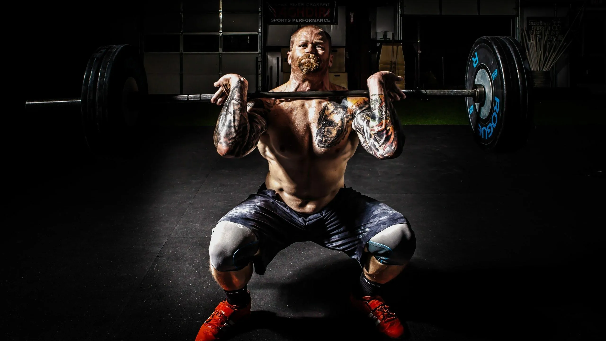 Man Performing Front Squat With Heavy Barbell Free Wallpaper