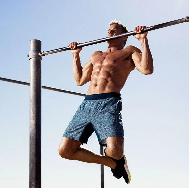 Man Performing Pull Ups on Bar in an Outdoor Workout Setting