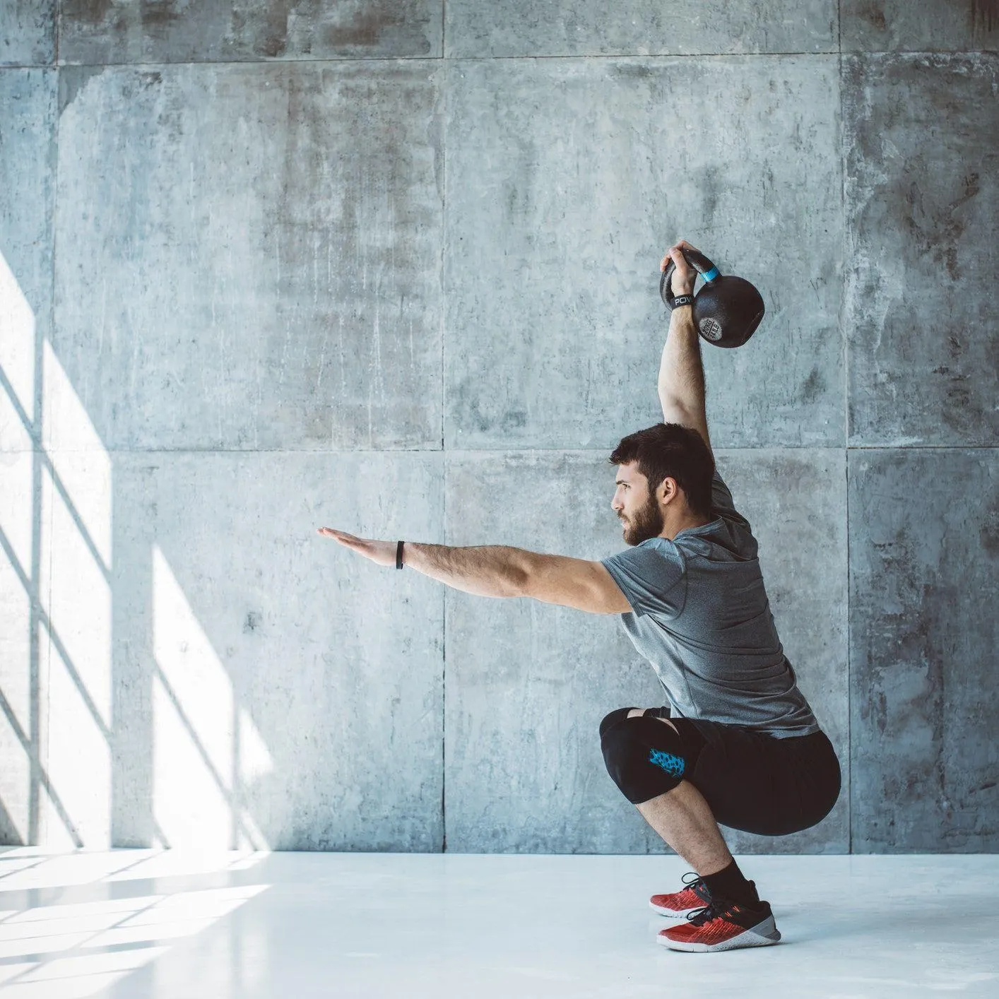 Man Performing Squats With Proper Form in a Bright Gym Space