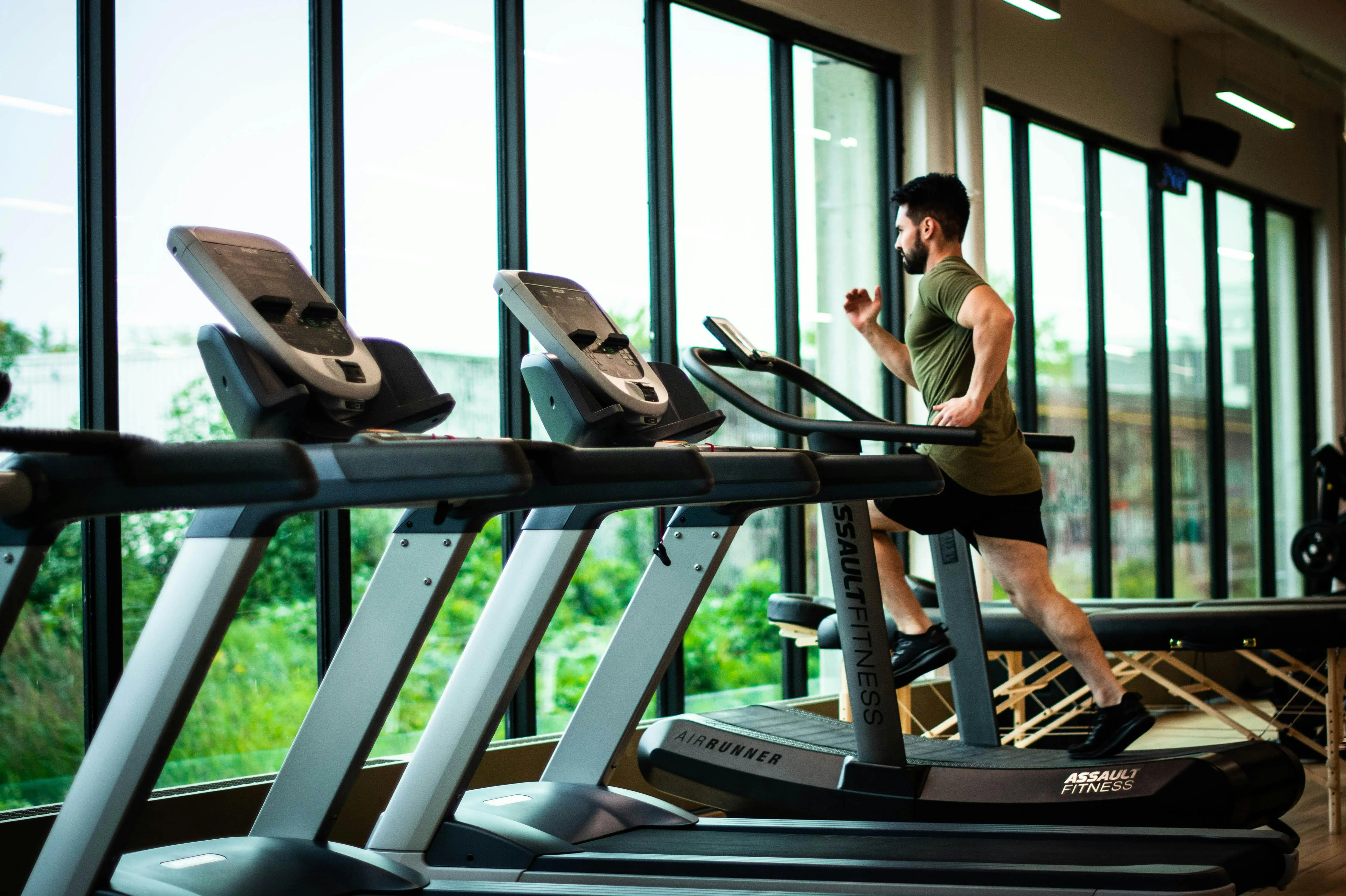 Man Running on a Treadmill Inside a Bright Modern Gym
