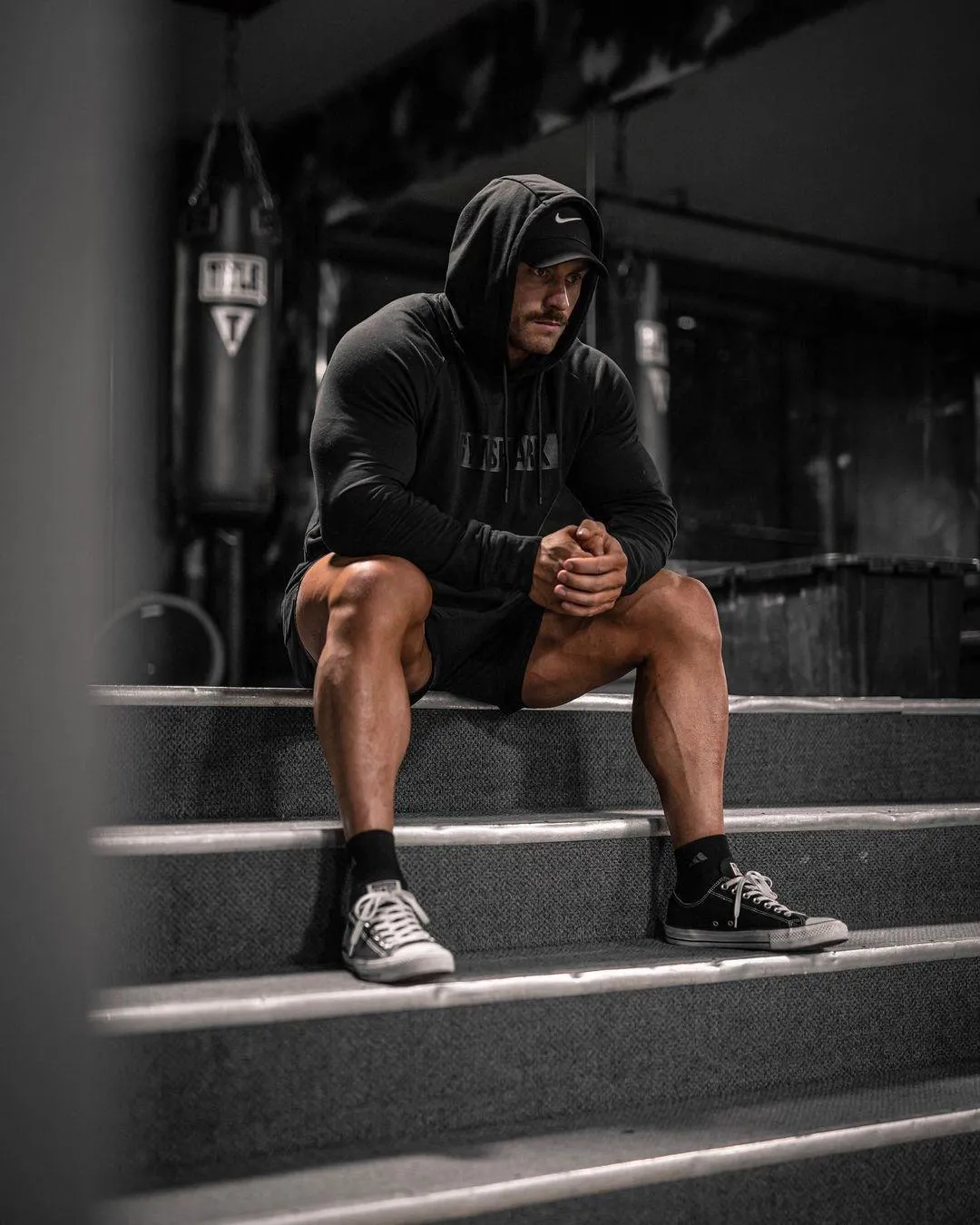 Man Sitting on Stairs Wearing Hoodie After Intense Workout