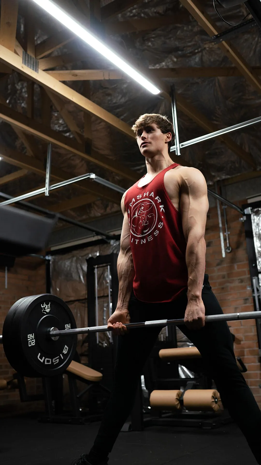 Man Standing Tall Lifting a Barbell in an Industrial Gym