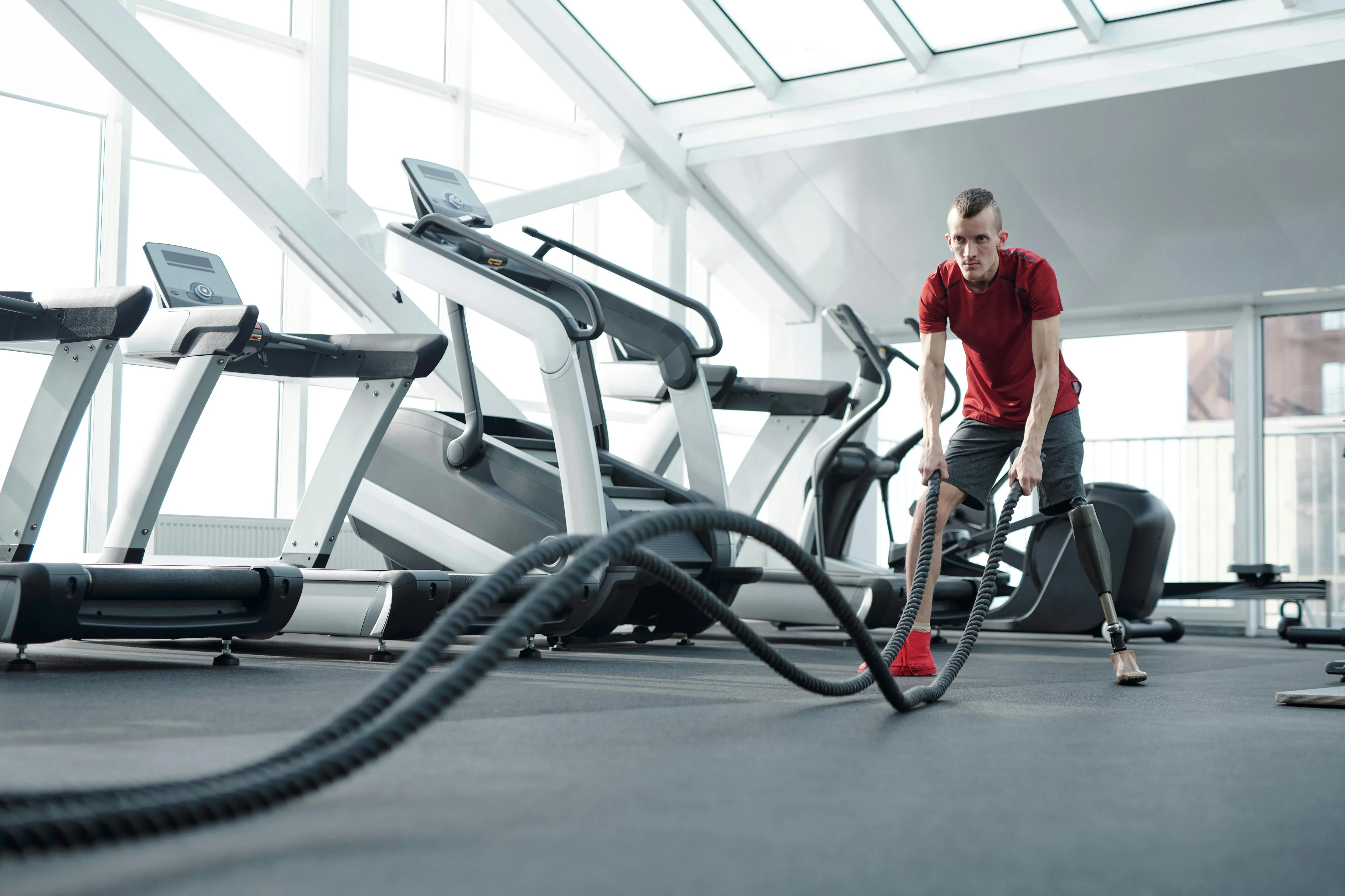Man Training With a Rope Near Treadmill in the Gym Wallpaper