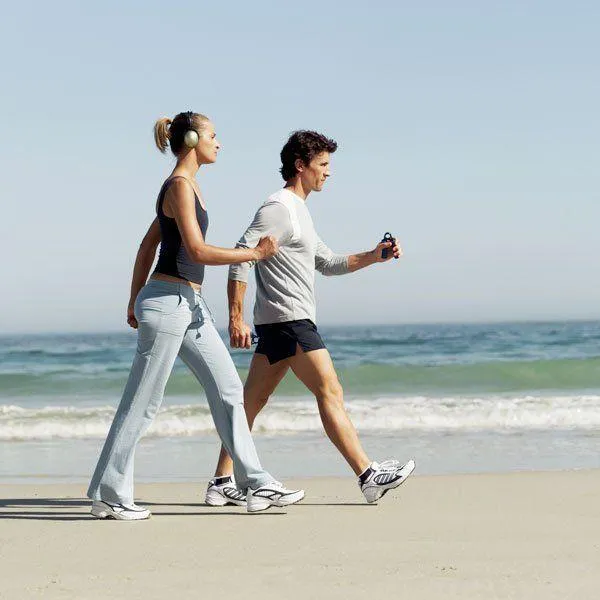 Man and a Woman Walking Together on Beach Enjoying Lifestyle