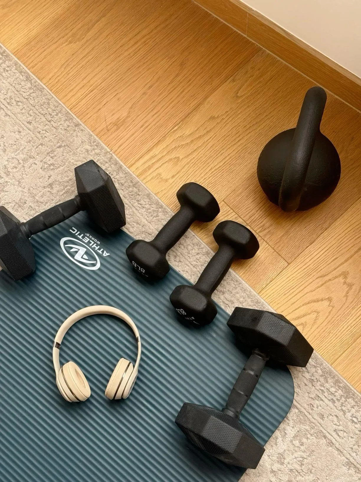 Minimal Home Gym Setup With Dumbbells Mat and Headphones