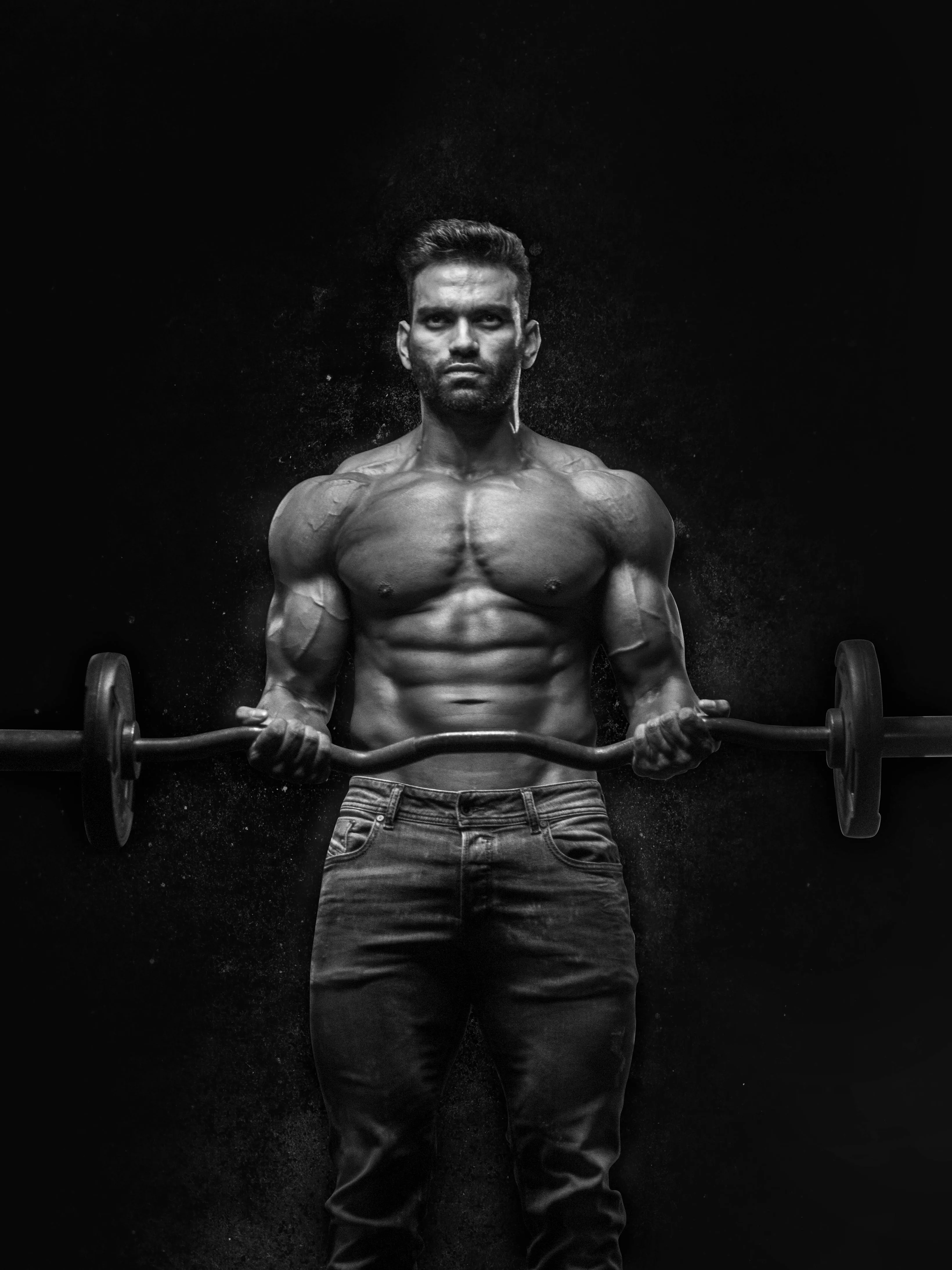 Muscular Man Holding a Barbell in a Dark Dramatic Setting