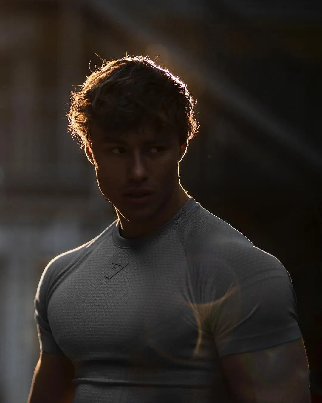 Muscular Man Posing in Dramatic Lighting With Shadowed Face