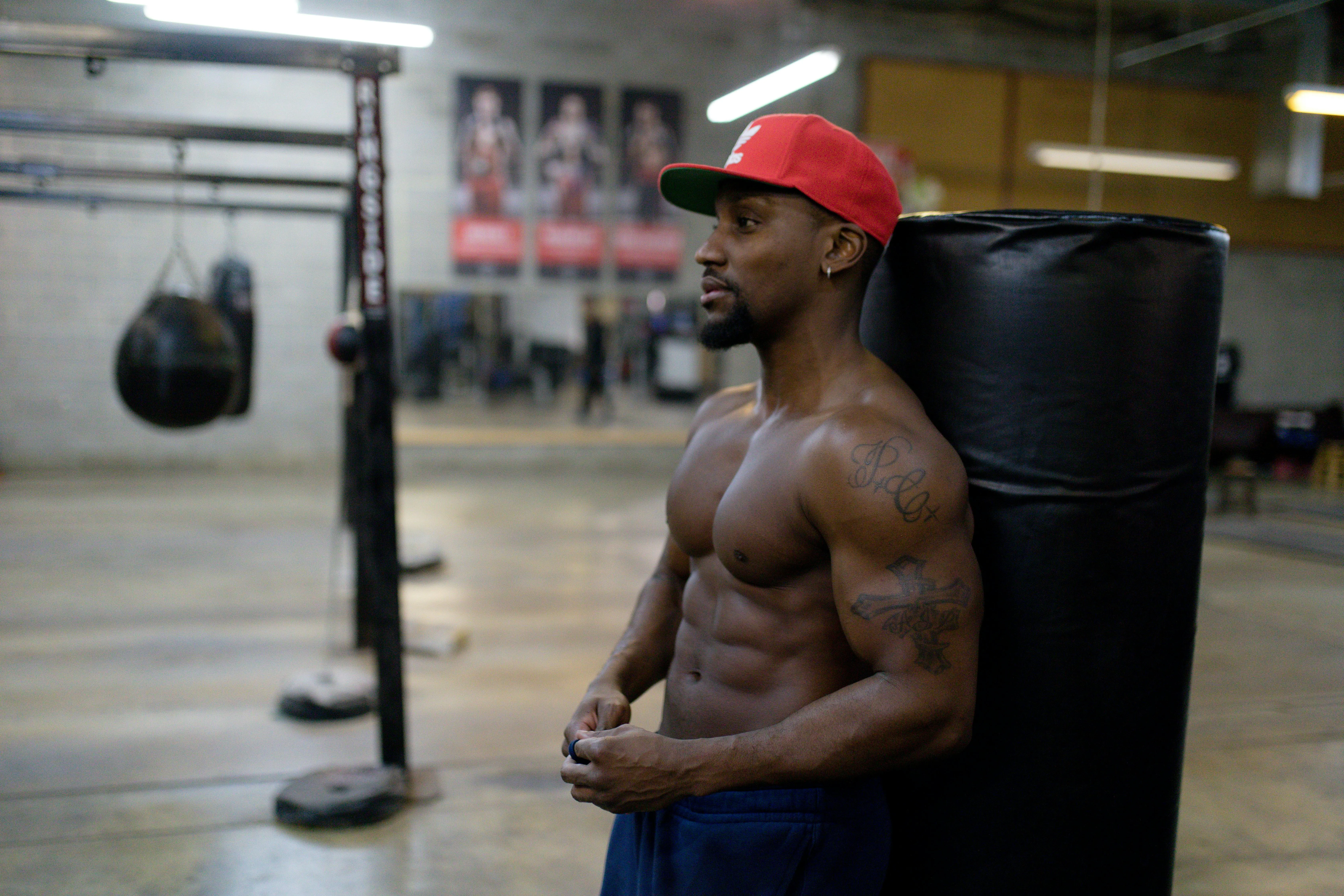 Muscular Man Standing Shirtless Near Boxing Equipment