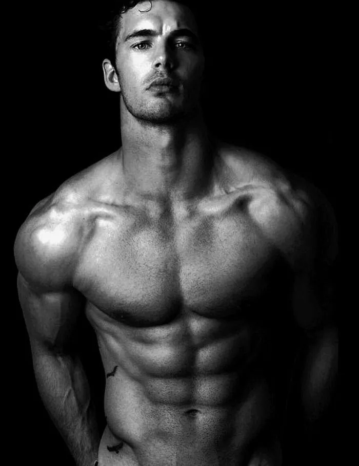 Shirtless Man Showing Muscular Physique in Black Light