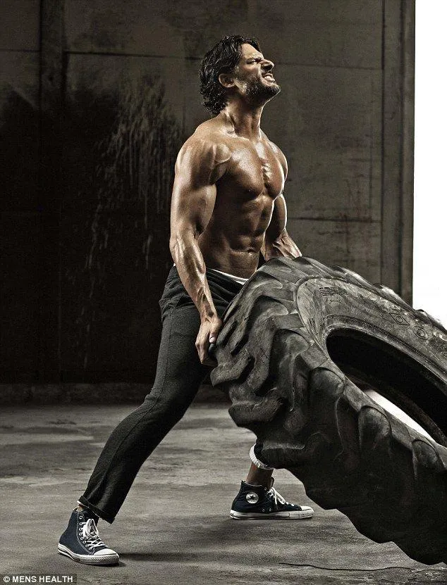 Strong Man Flipping a Giant Tire in a Gritty Gym Wallpaper