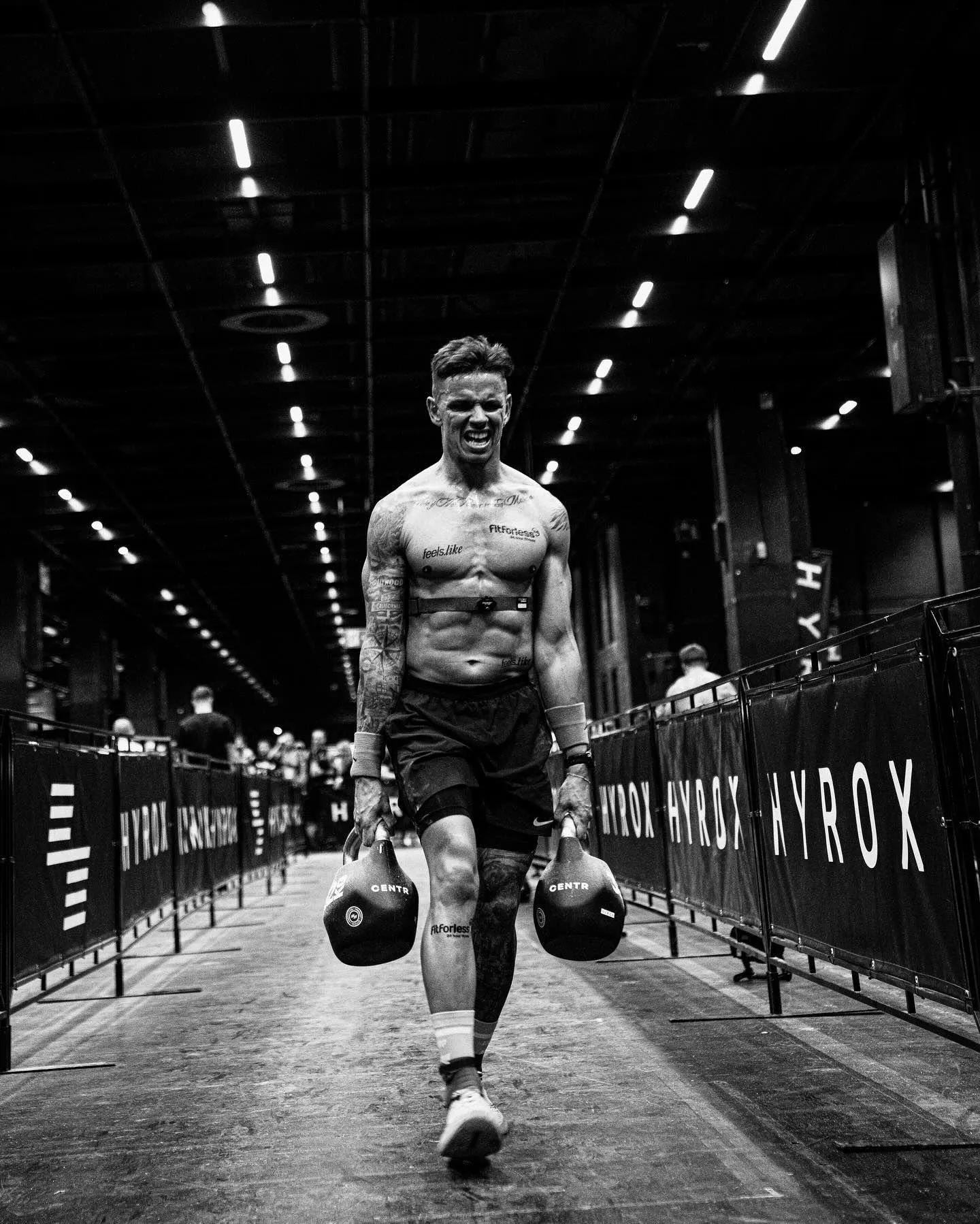 Strong Man Walking With Heavy Kettlebells in Black and White